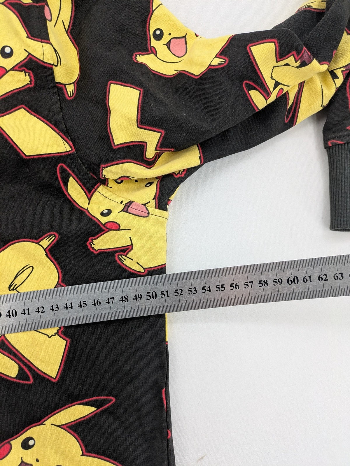 Herren black zip-through hoodie with vibrant Pikachu allover print and yellow lining.