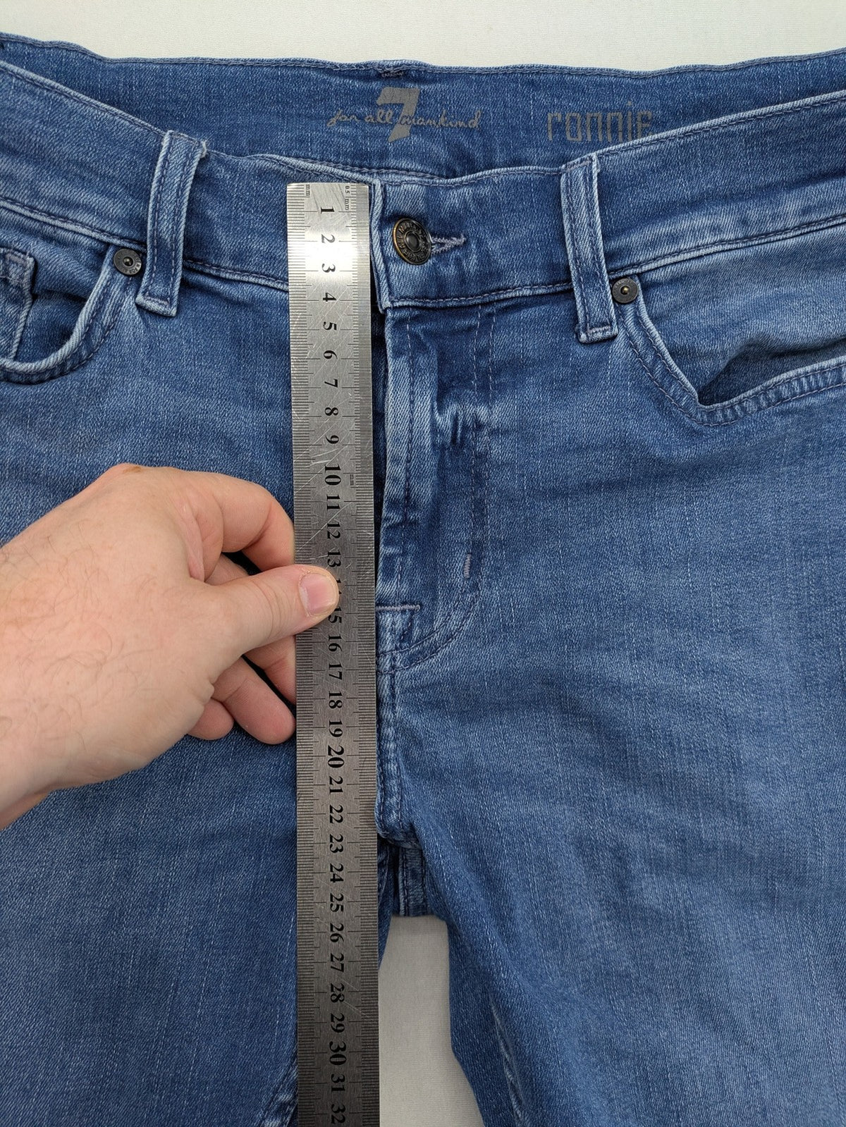 7 For All Mankind blue straight jeans with 5-pocket design and logo on back pocket.