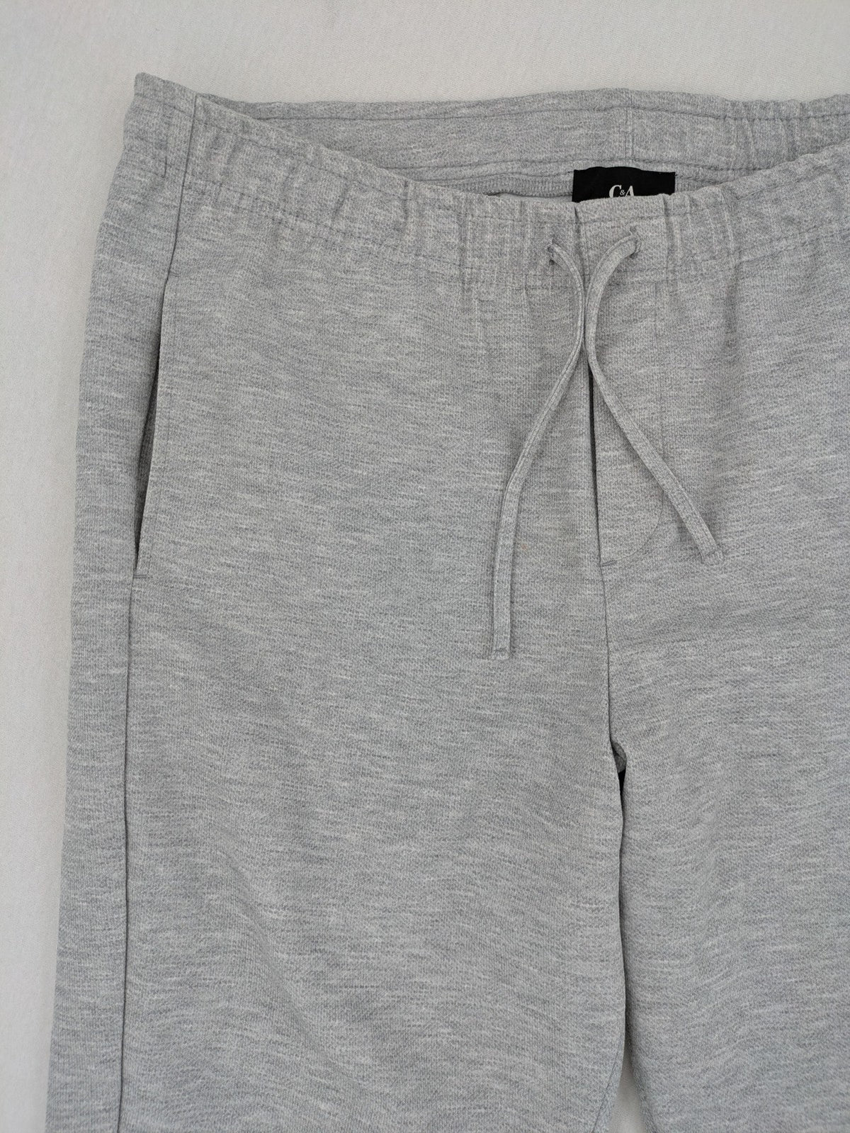 C&A grey sweatpants with elastic waistband, adjustable drawstring, and side pockets.