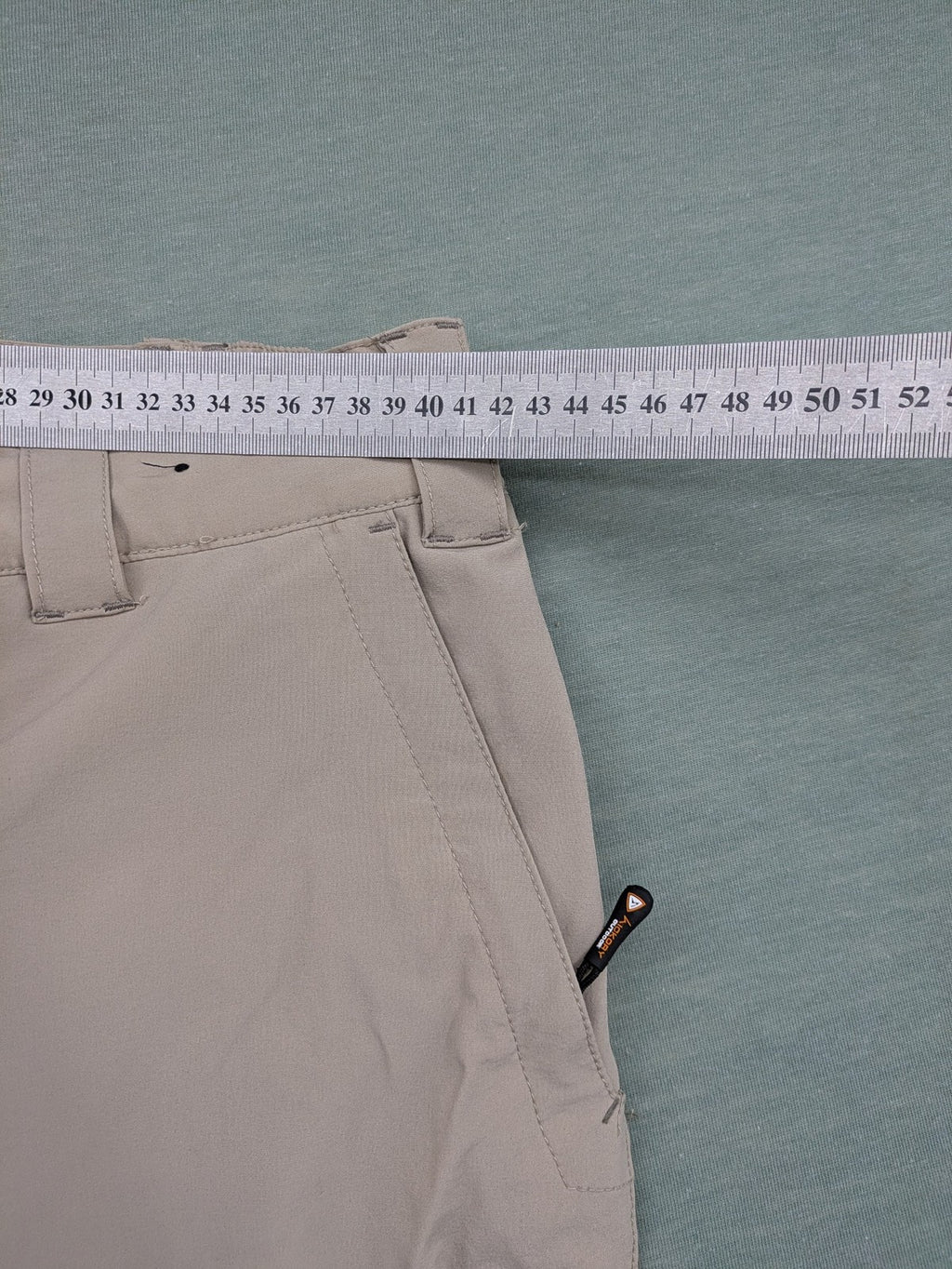 Hickory beige outdoor pants with multiple zippered pockets and stretch fabric for comfort.