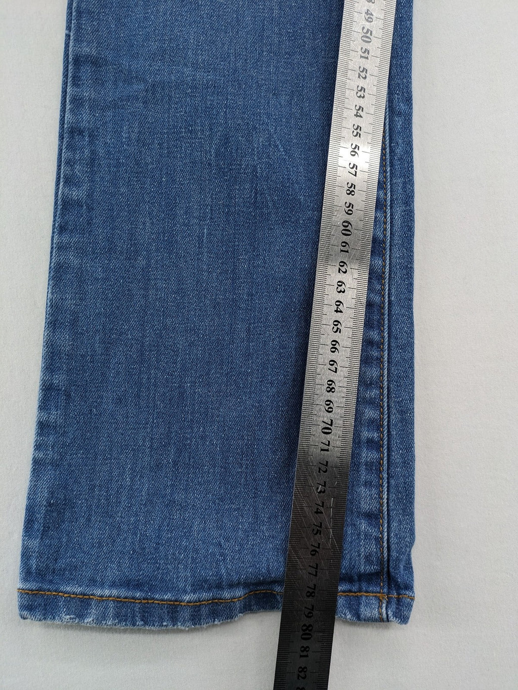Denim blue straight jeans low rise bootcut with classic 5-pocket design and subtle rivets.