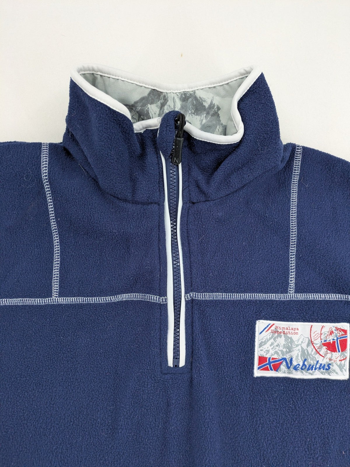 Nebulus navy turtle neck jumper with graphic print collar and "Himalaya Expedition" patch.