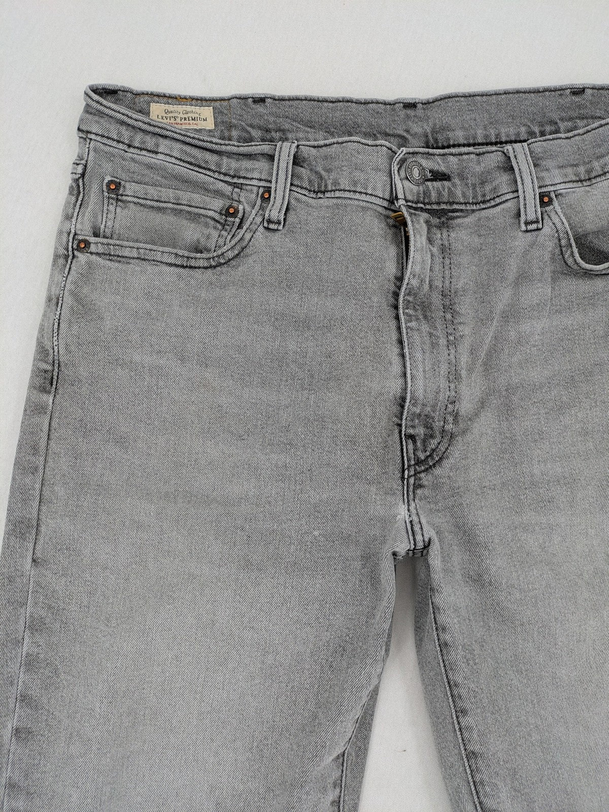 Levi's grey slim fit jeans with distressed knee details and classic logo patch.
