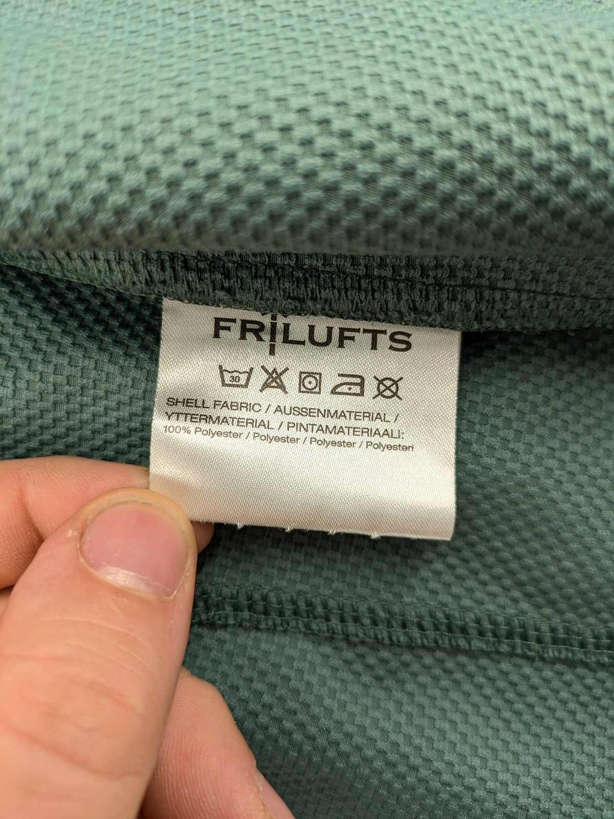 Frilufts green softshell jacket with hood, longline design, durable zipper, practical zip pockets.