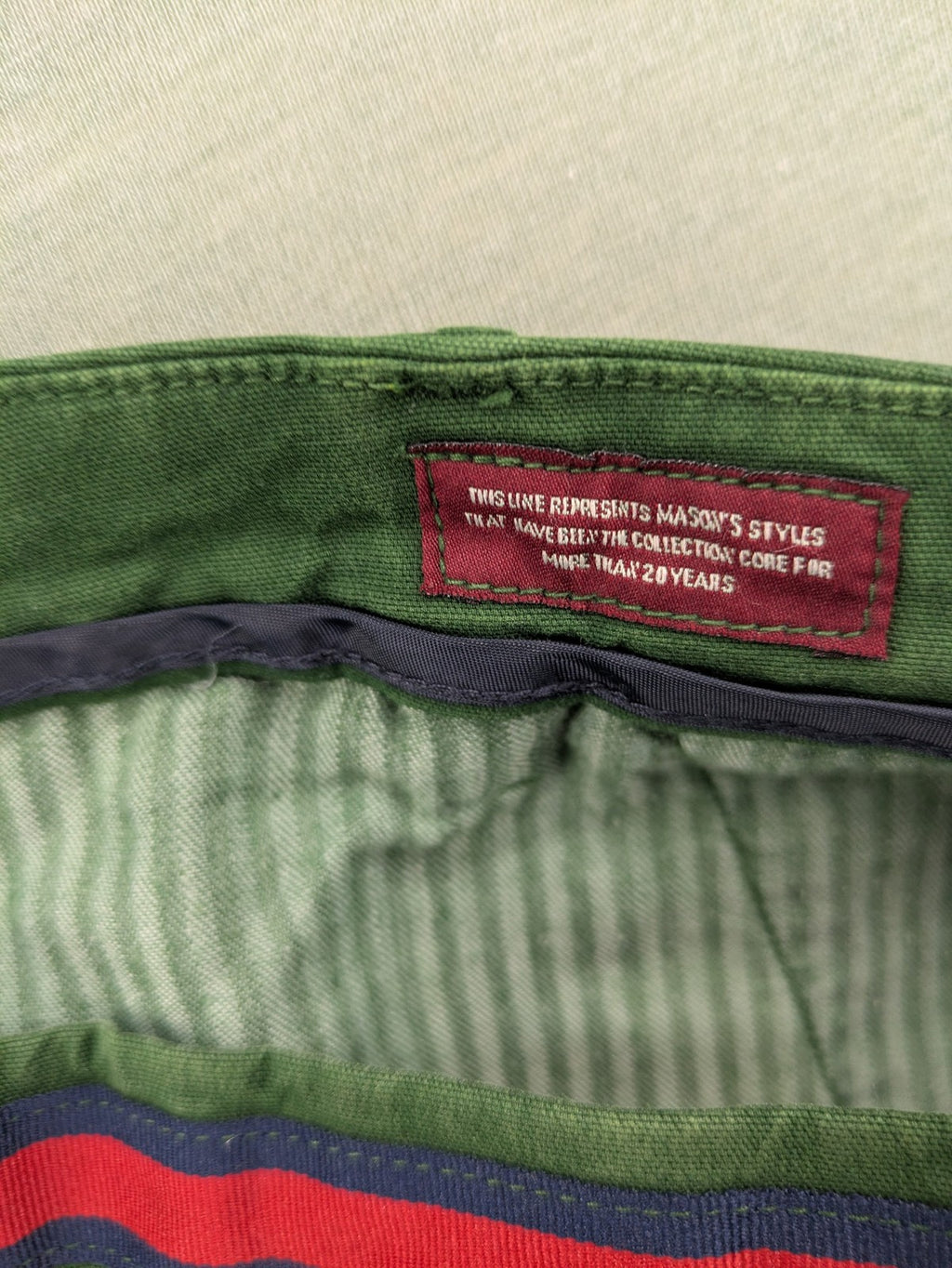 Mason's green chino pants with striped red and blue waistband, cotton stretch material.