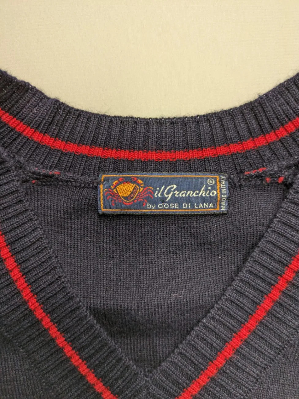 Il Granchio grey turtle neck jumper with red accents and embroidered crab logo.