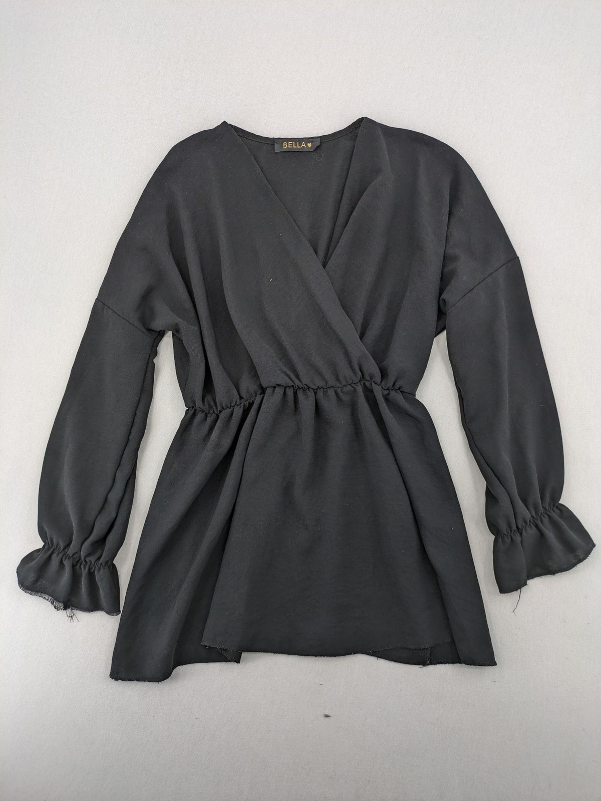 Bella black wrap blouse with deep V-neck and ruffled long sleeves.