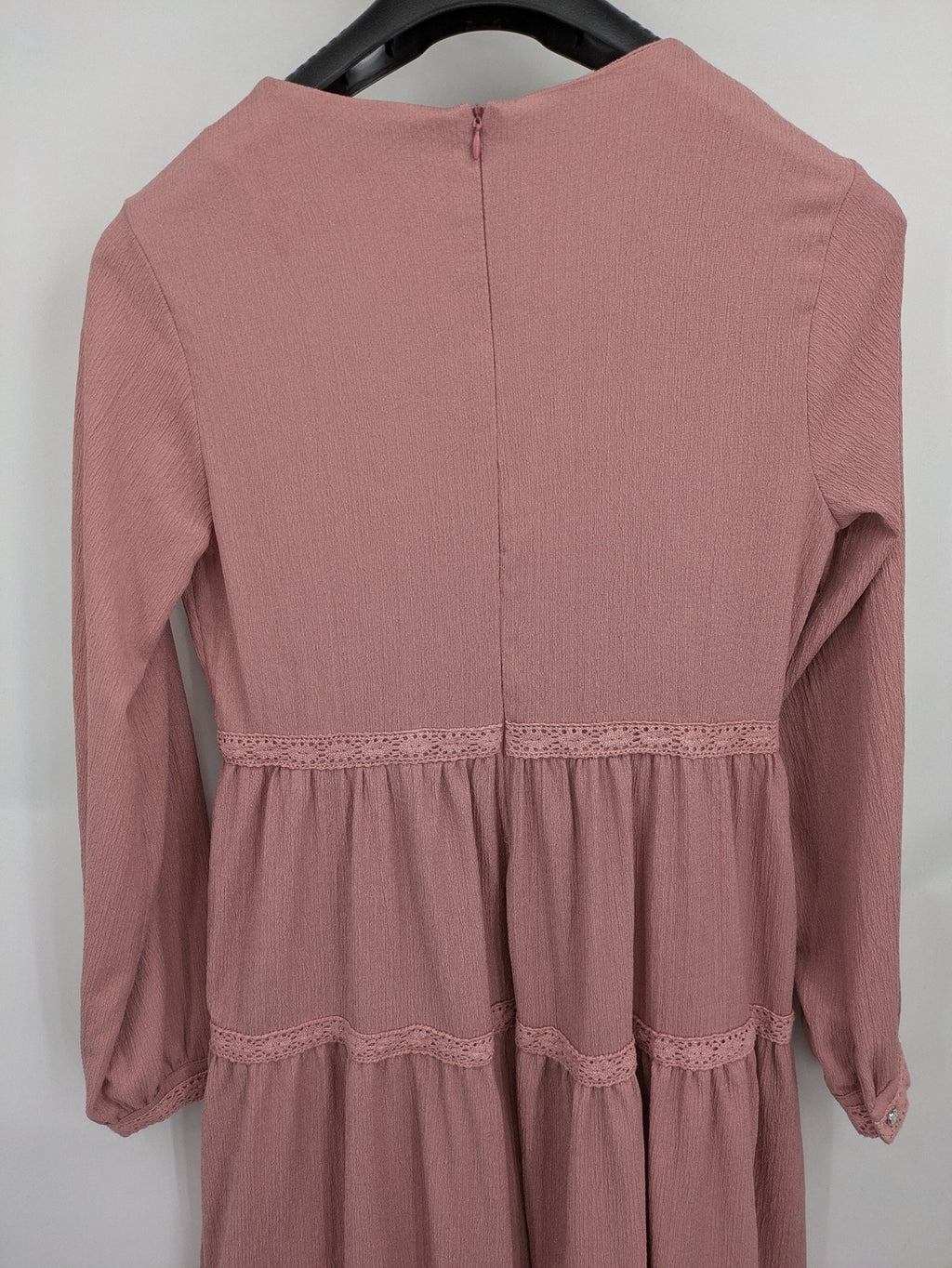 Moda pink bridal party dress with lace inserts, long sleeves, and tiered design.