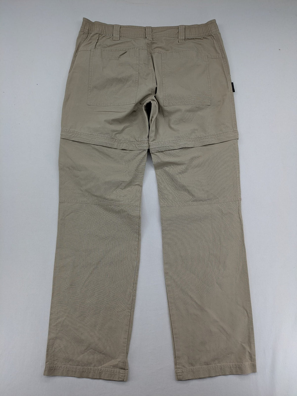 Quechua khaki convertible hiking pants with zip-off legs and durable cotton fabric.