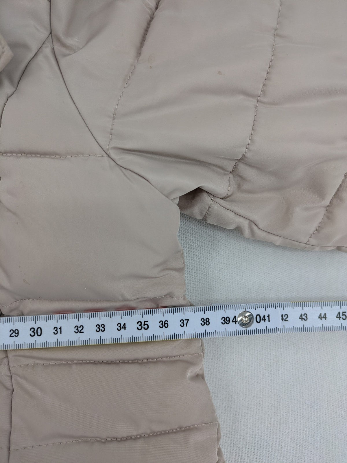 Brit Island beige puffer coat with fleece lining and faux fur hood detail.