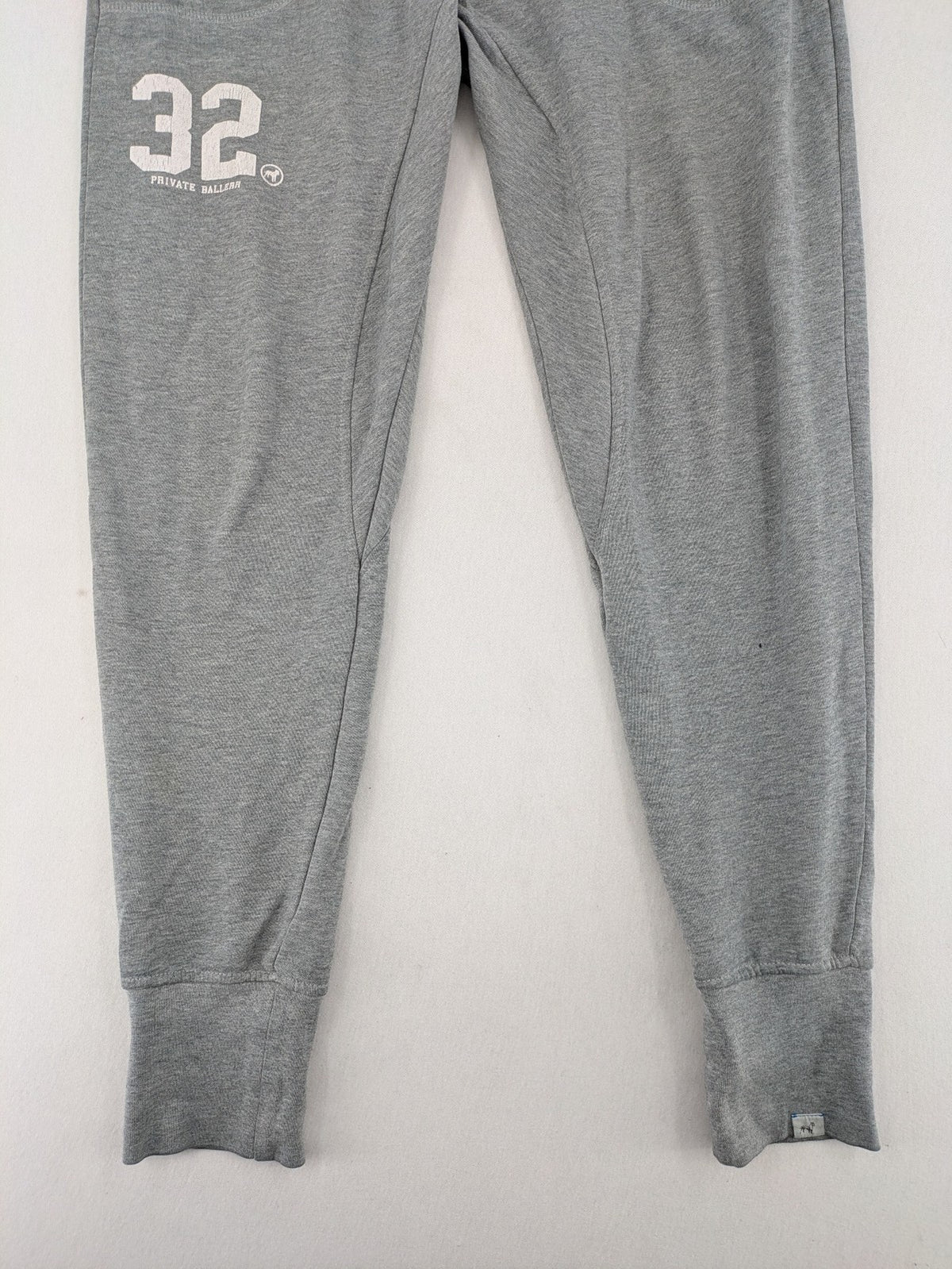 Private Baller grey sweatpants with "32" graphic print and blue drawstring.