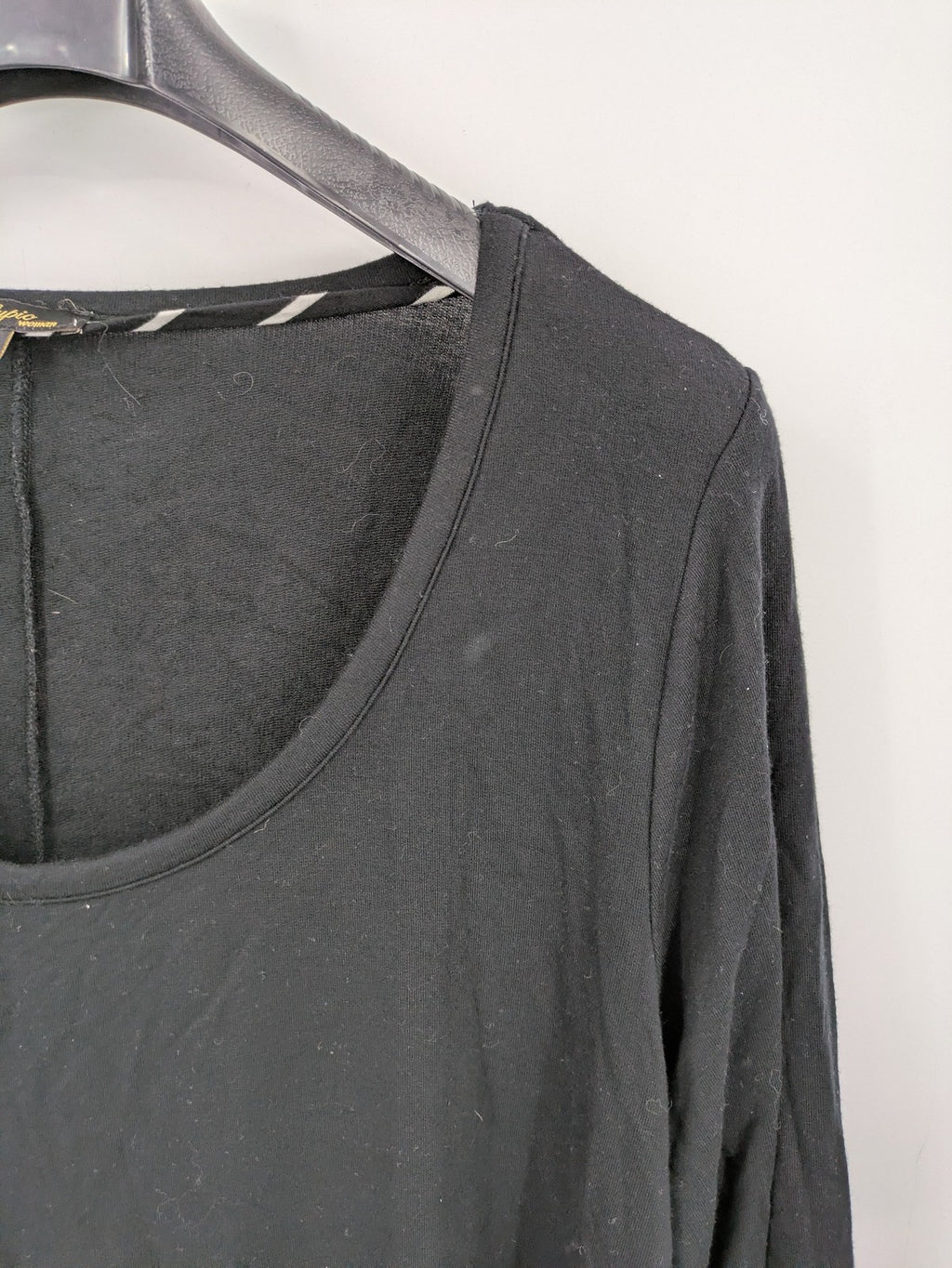 Cupio black long sleeve tunic with side button placket and high-low hem.