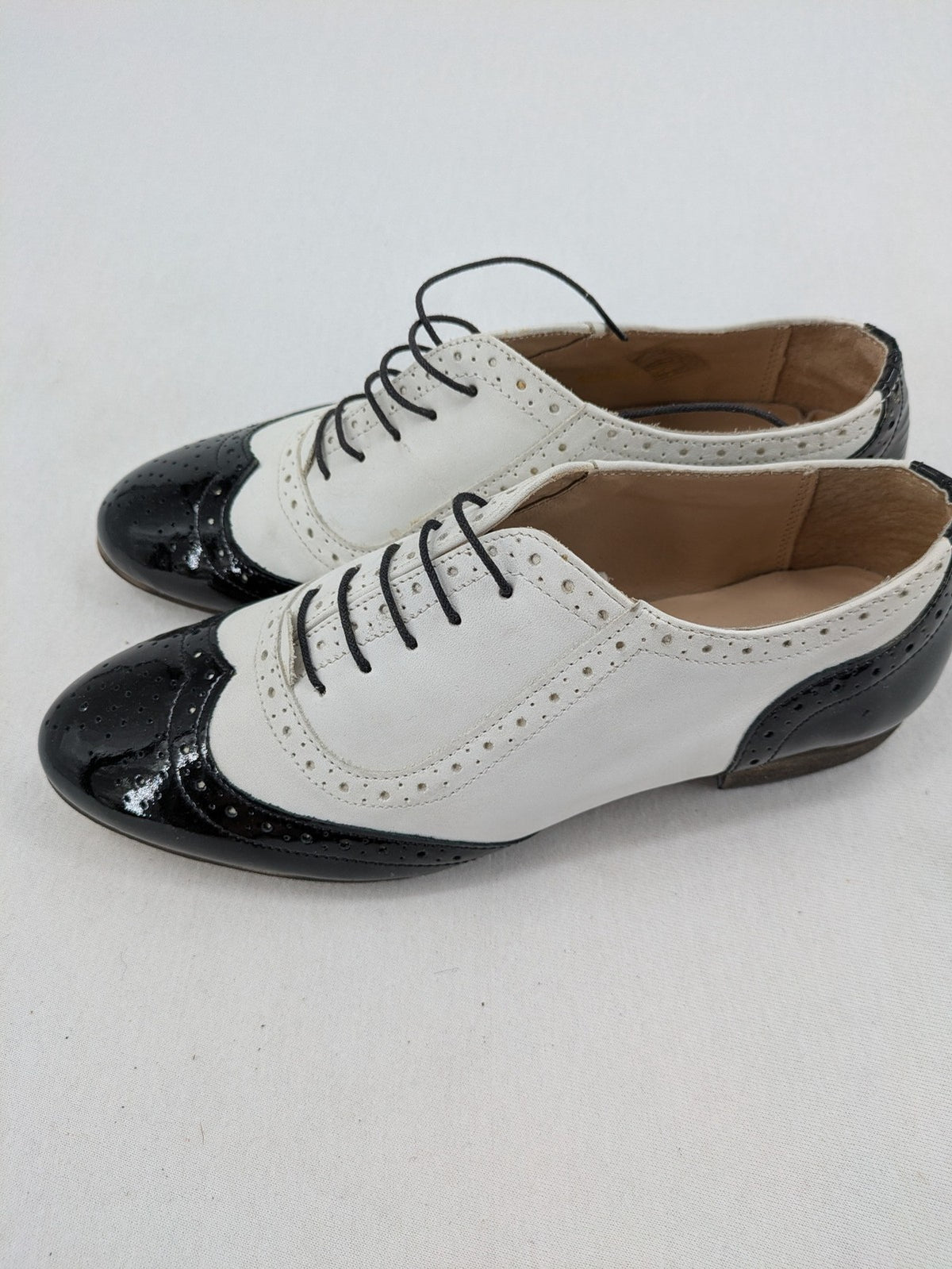 Kontrast black and white deck shoes, glossy patent leather with wingtip cap and brogue detailing.