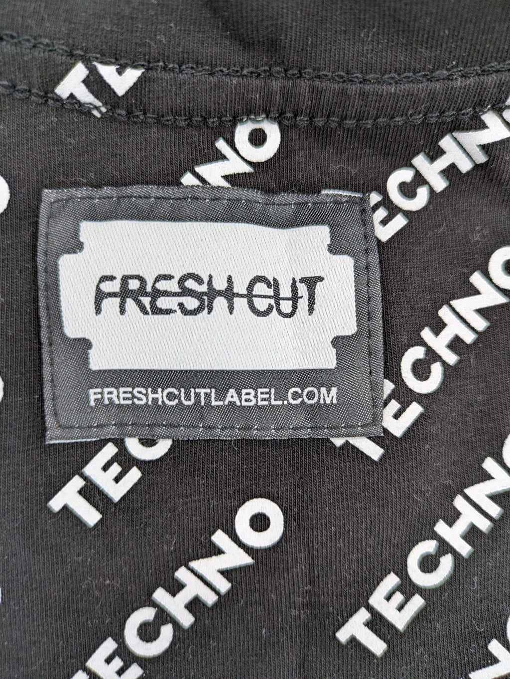 Fresh Cut black techno t-shirt all-over print with bold "TECHNO" graphic design.