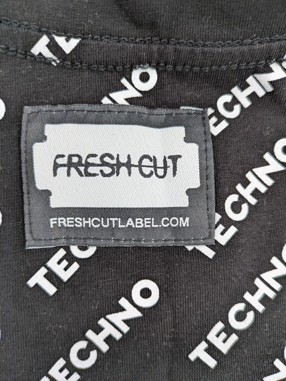 Fresh Cut black techno t-shirt all-over print with bold "TECHNO" graphic design.