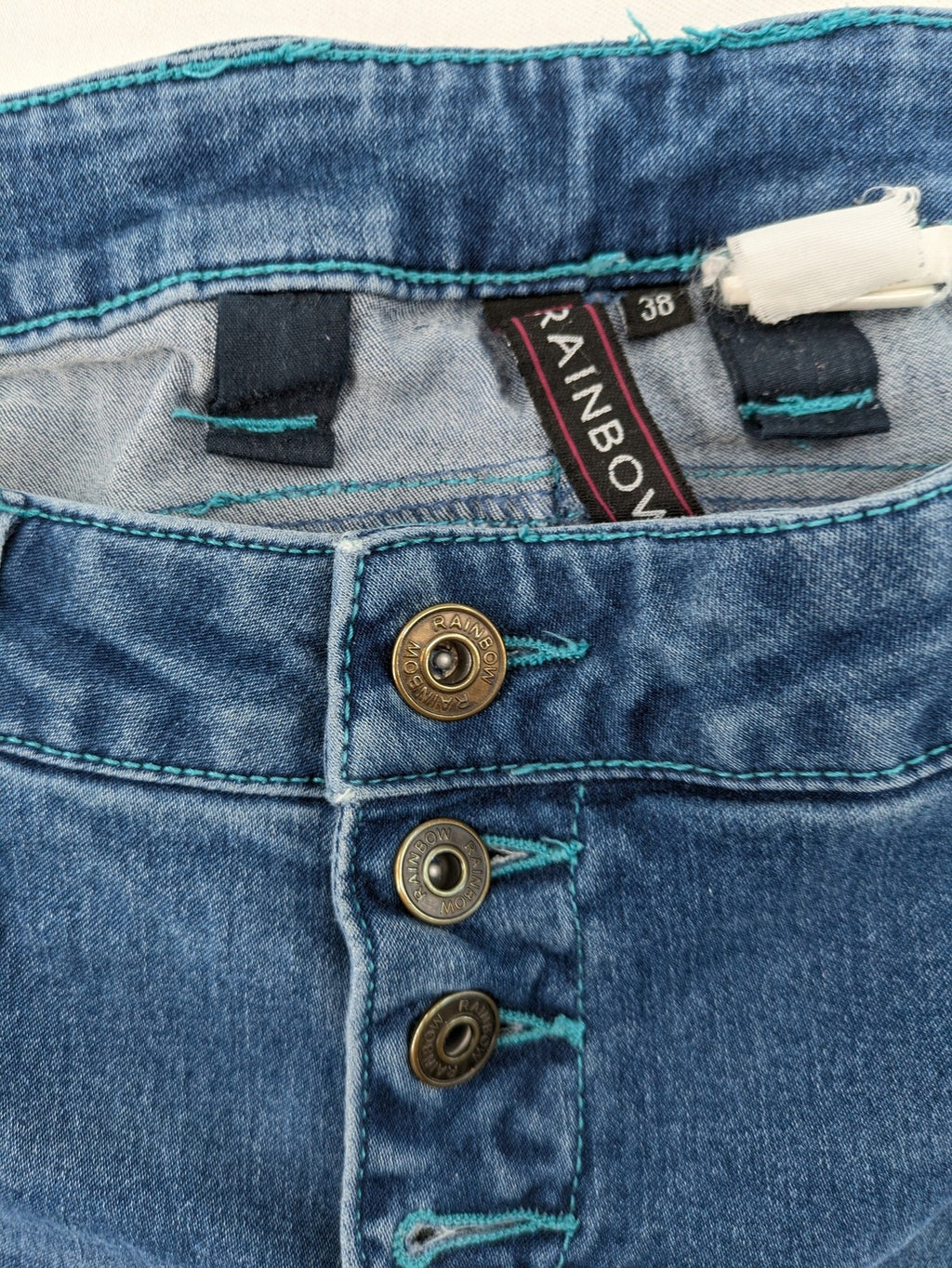 Rainbow blue straight jeans jogger style with button fly and contrasting turquoise stitching.