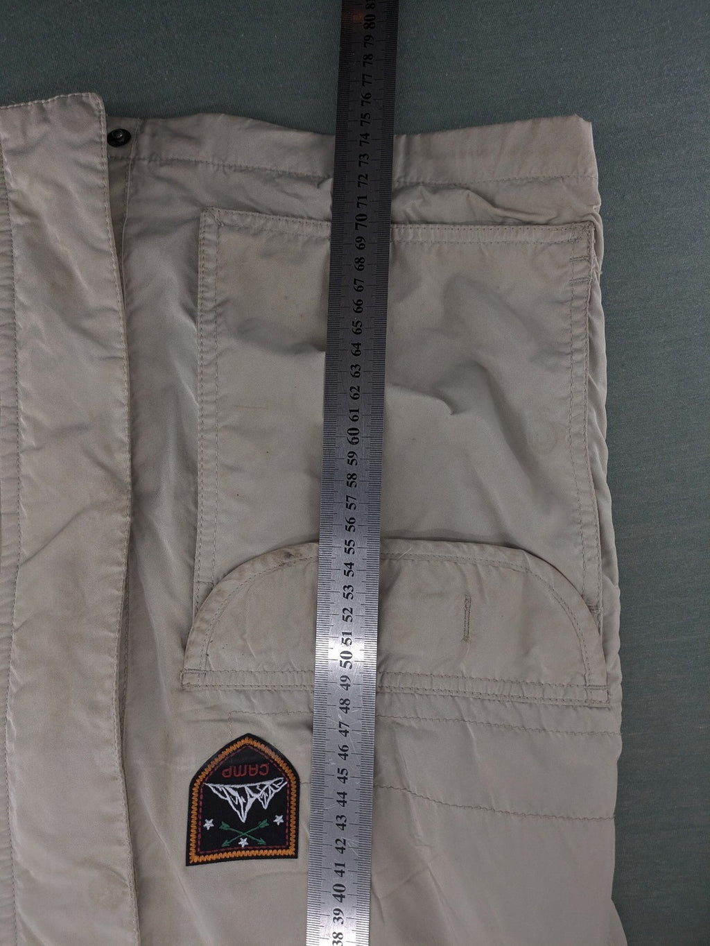 Camp David beige field jacket with logo patches, standing collar, and multiple pockets.