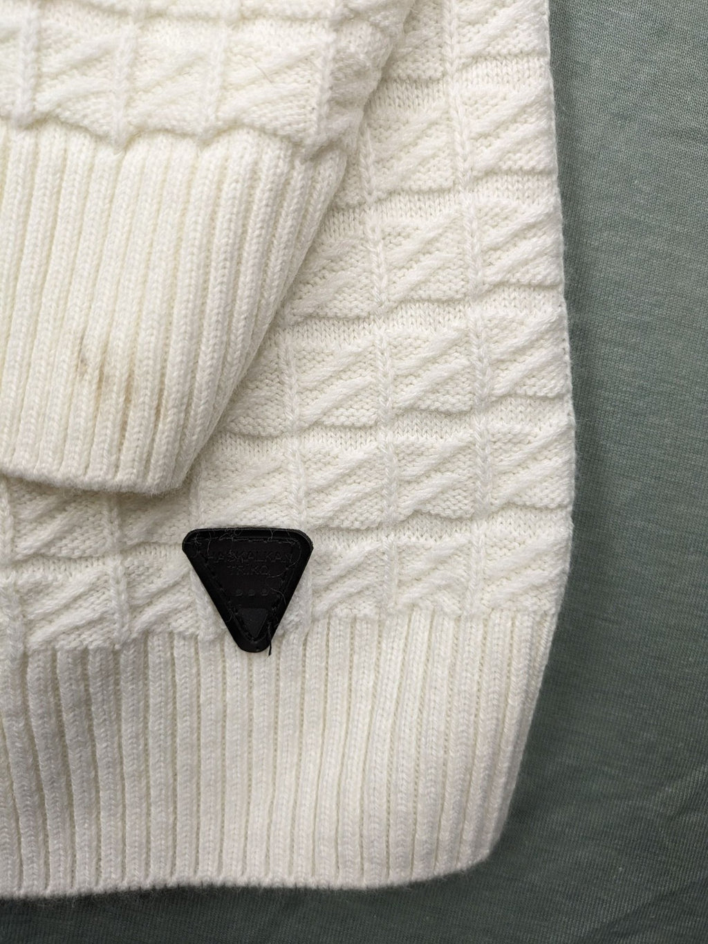 Haskalkan white turtle neck jumper with geometric textured pattern and ribbed cuffs.