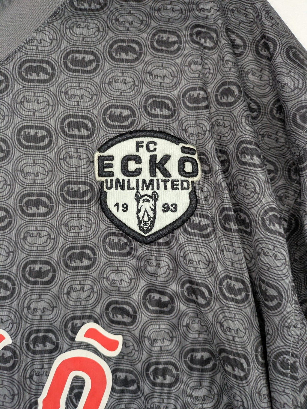 Ecko Unltd. grey soccer uniform V-neck with all-over logo print and embroidered FC patch.