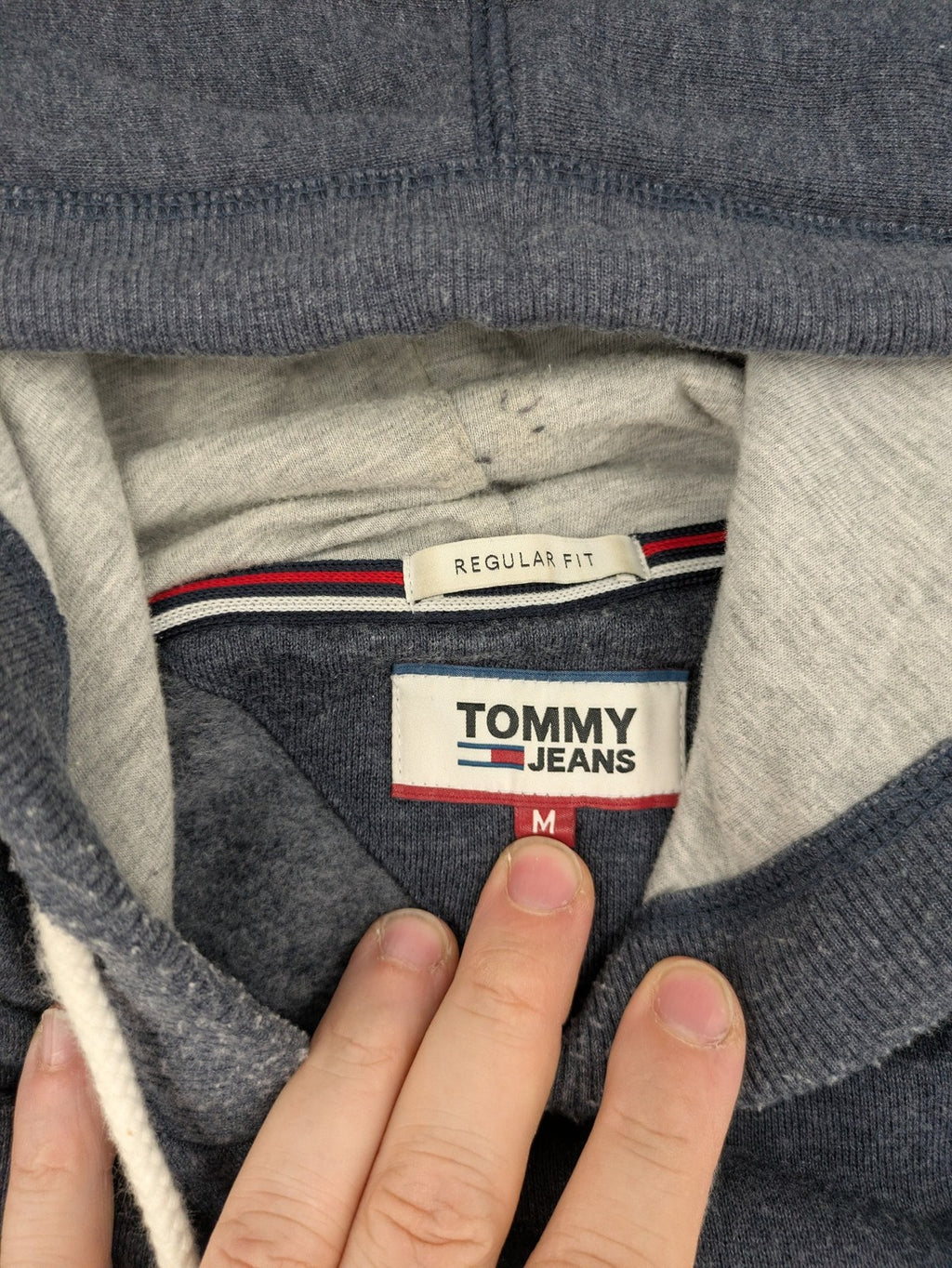 Tommy Jeans blue full zip hoodie with logo, adjustable hood, and kangaroo pockets.