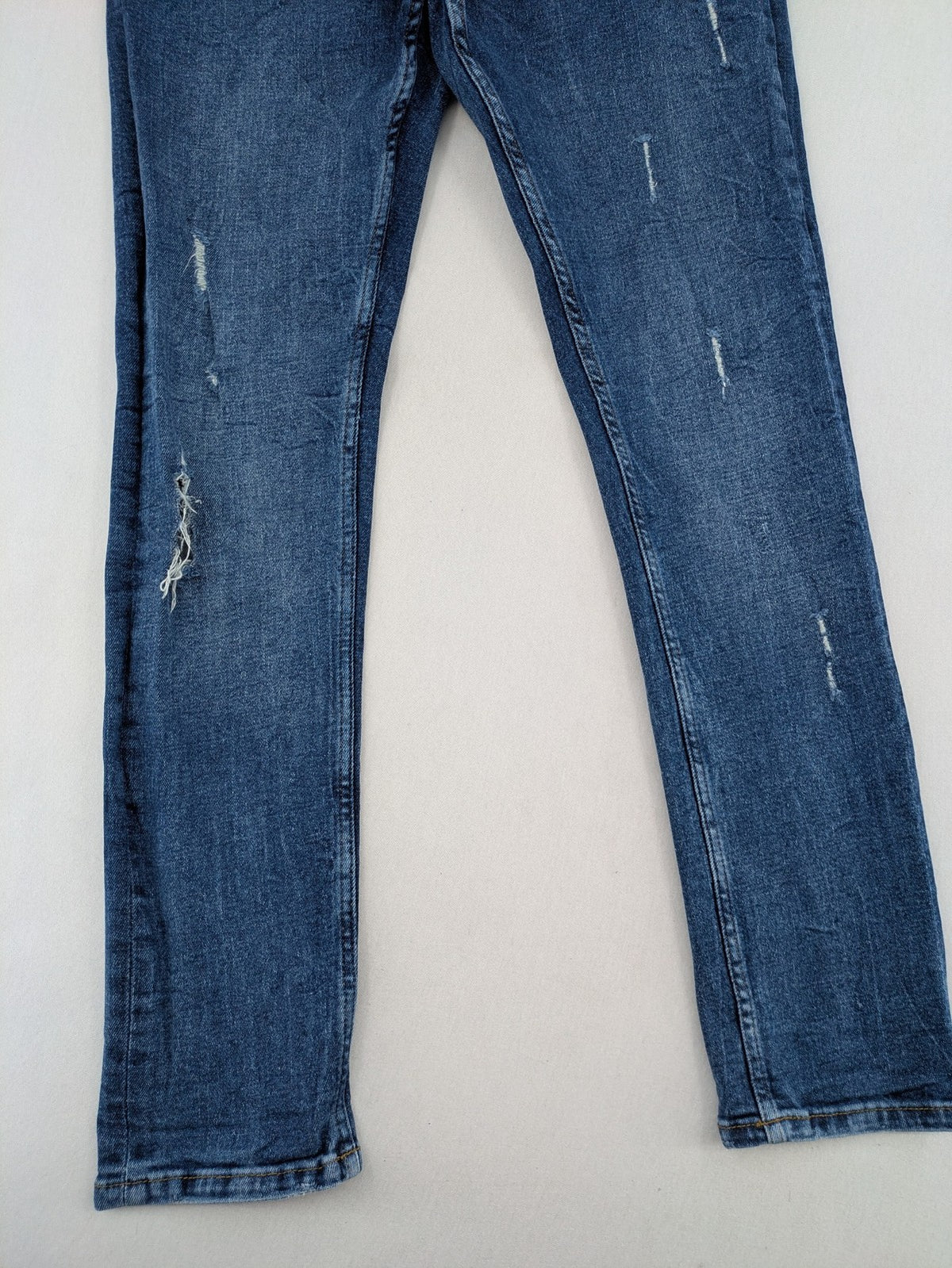 2Y Premium blue skinny jeans with distressed details and classic button fly.