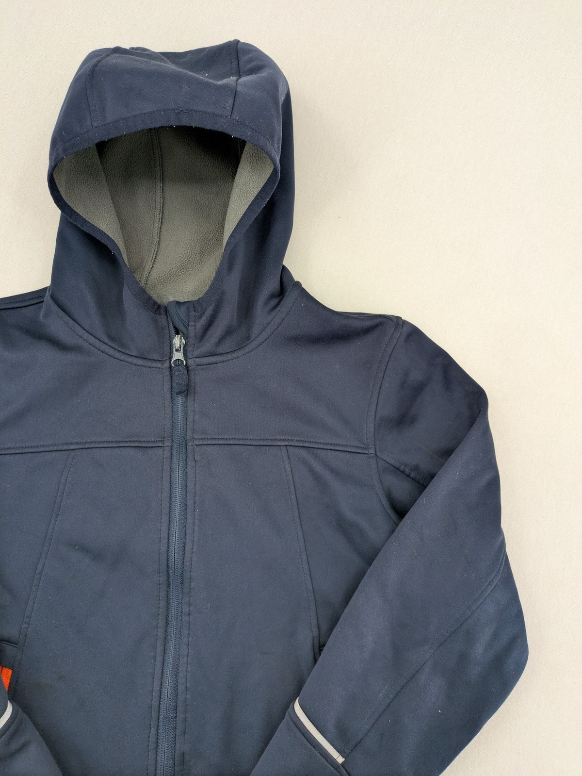 Crane navy softshell jacket with fleece lining, full zip, orange accent zippers.