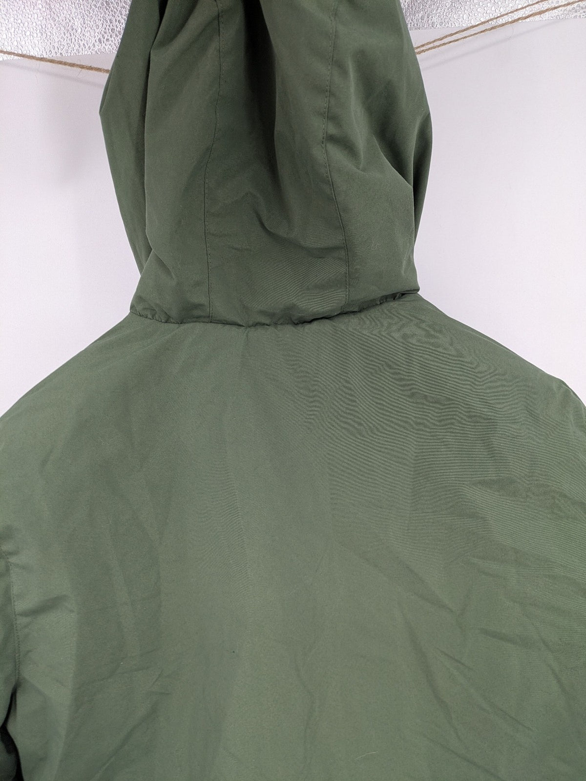 Bad Choices green parka coat with reflective details and logo patch on sleeve.
