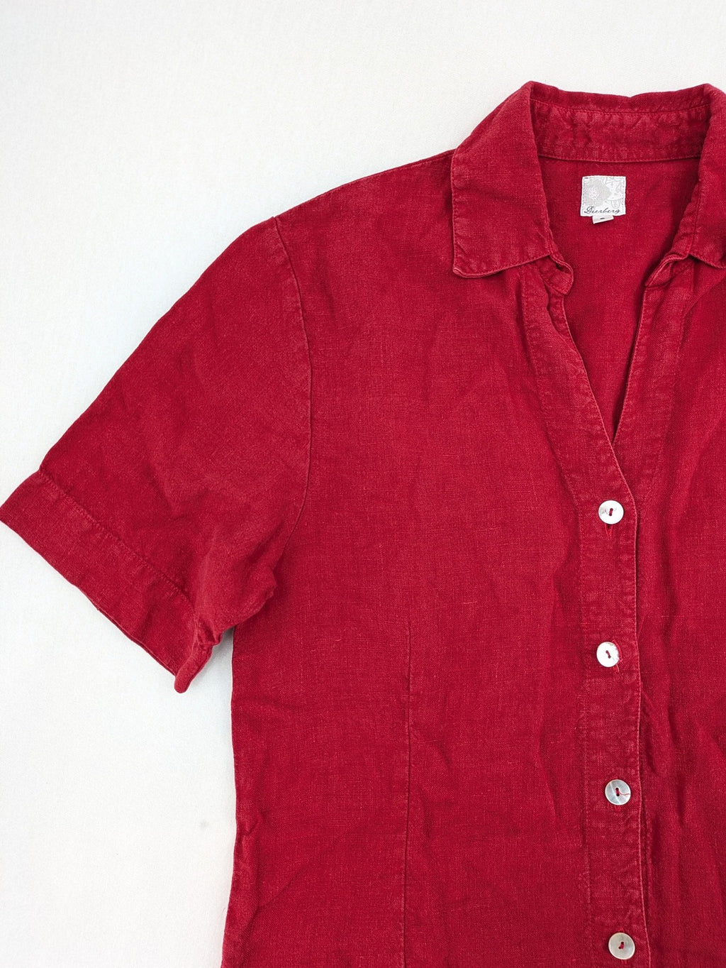 Deerberg red short-sleeve linen blouse with collar, button placket, and side slits.