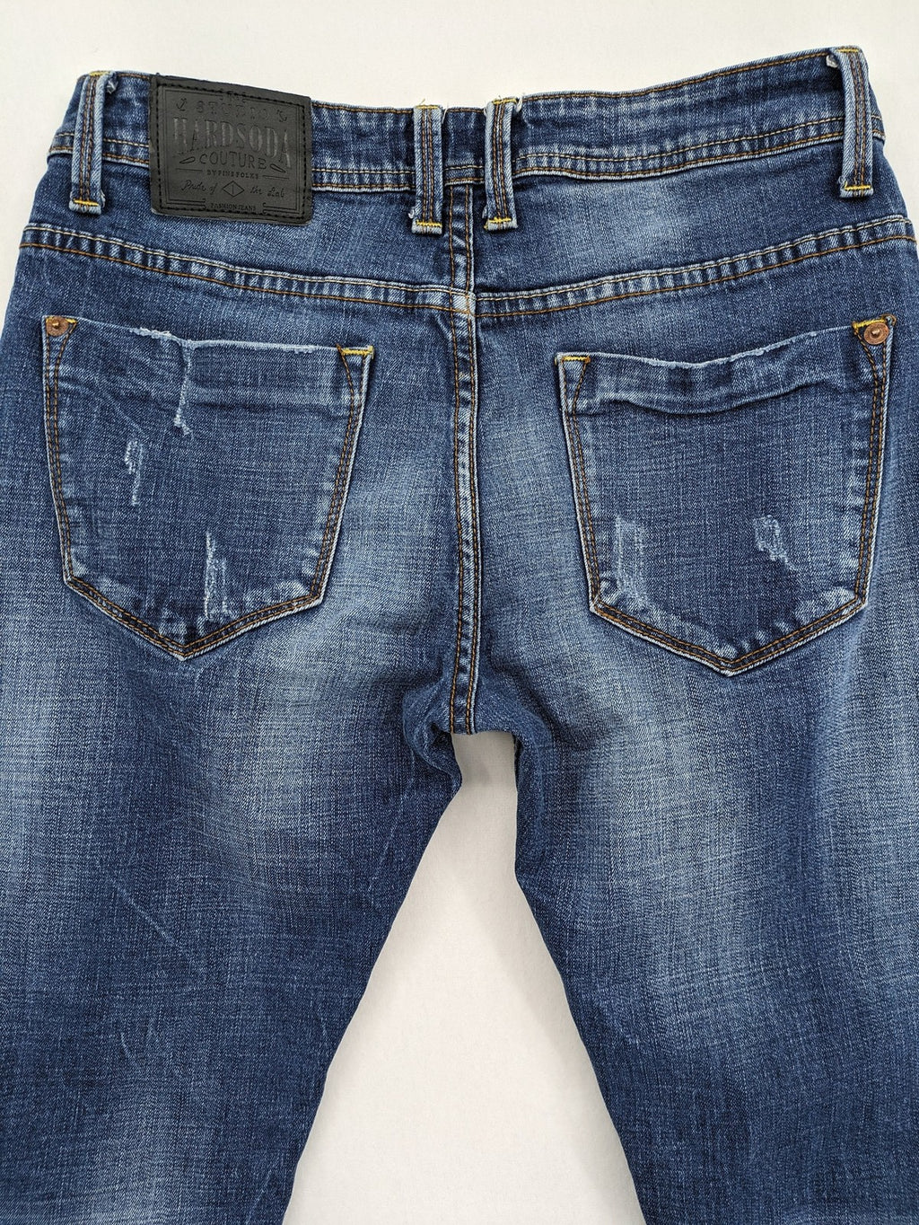 Soda blue straight jeans with distressed rips and button fly, cotton blend material.