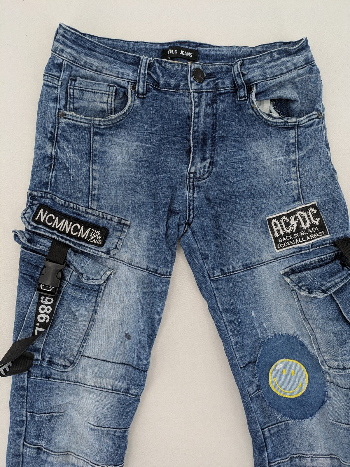 FN.G blue straight jeans with AC/DC patch, smiley face, and elastic jogger cuffs.