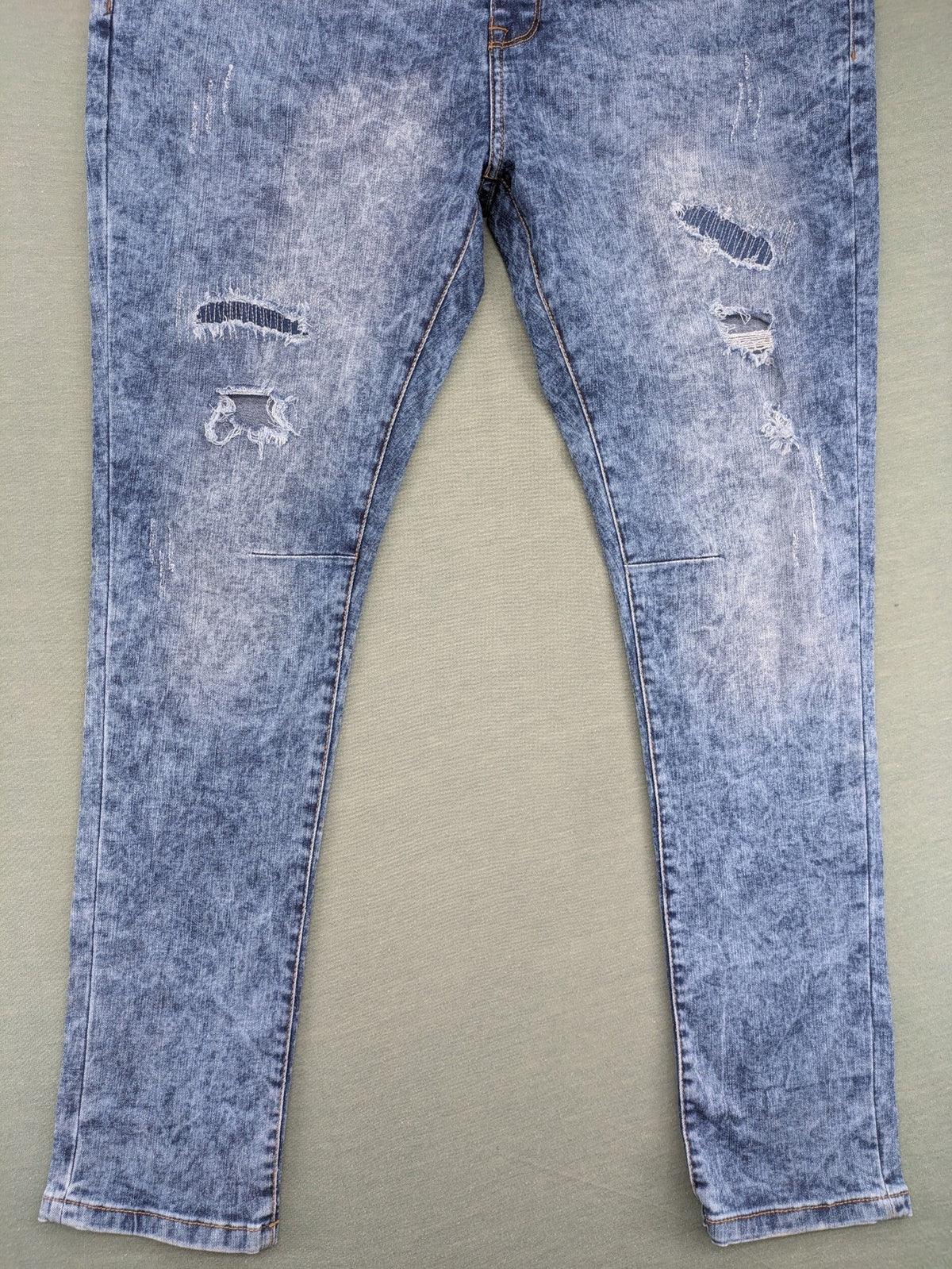 Janina blue slim fit jeans with acid wash, destroyed details, and button fly.