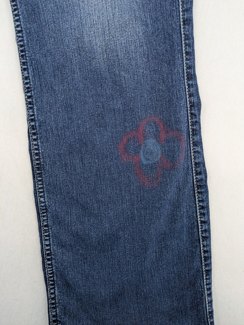 Mustang blue bootcut jeans with custom painted floral designs on both legs.