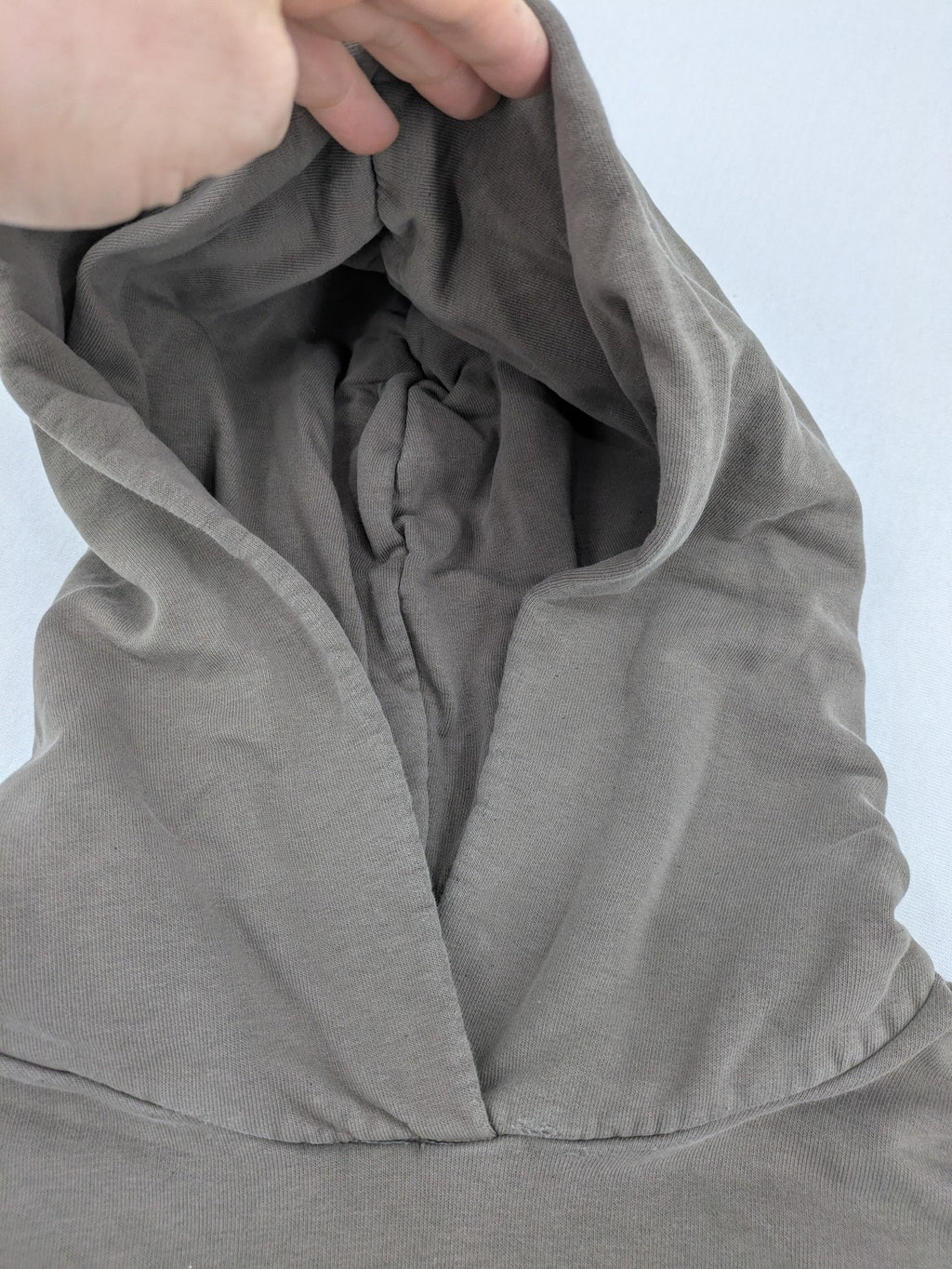 Mosquito grey hoodie with distressed cuffs and subtle logo on the chest.