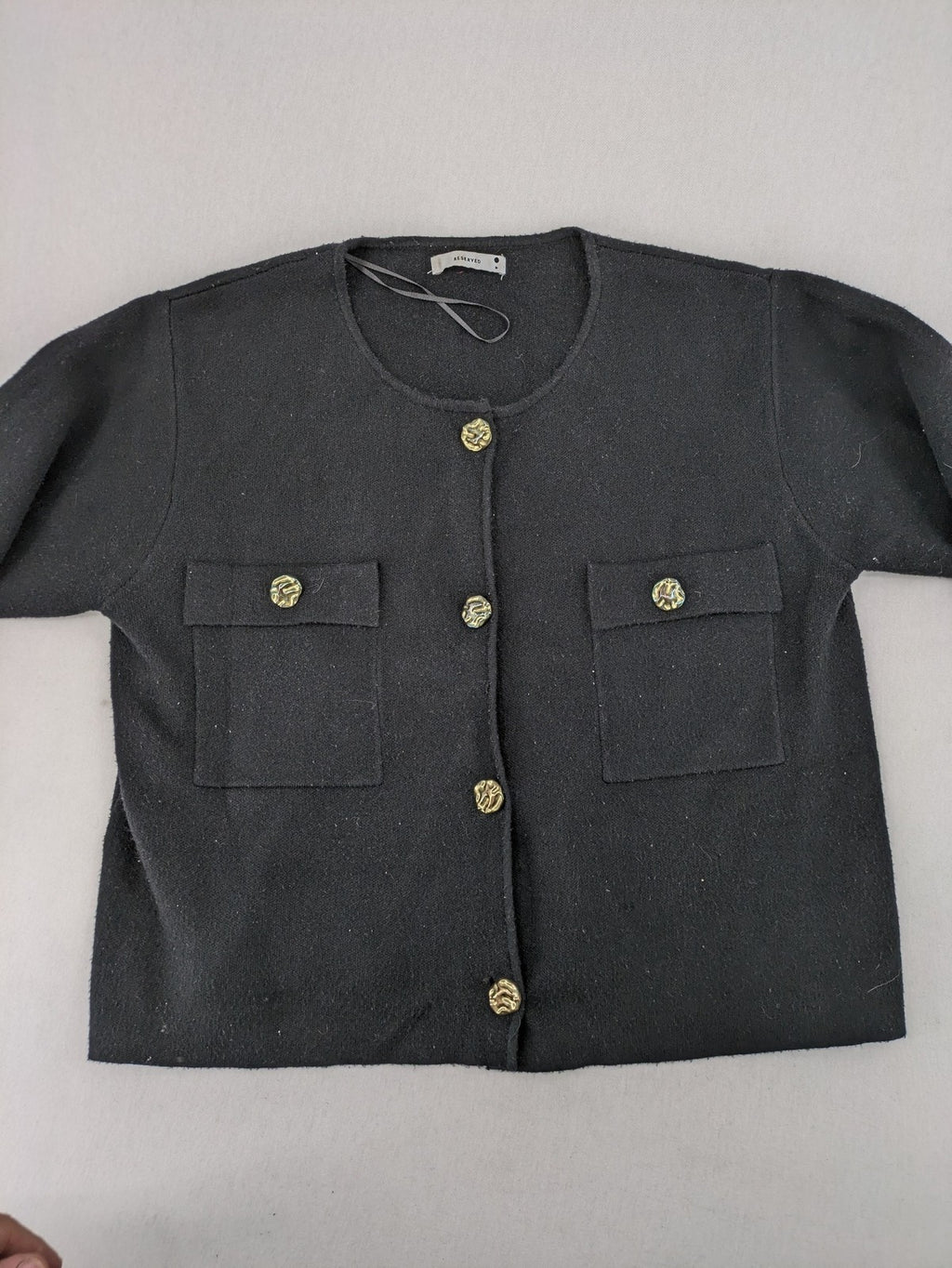 Reserved gold turtle neck jumper with black knit, gold button details and front pockets.