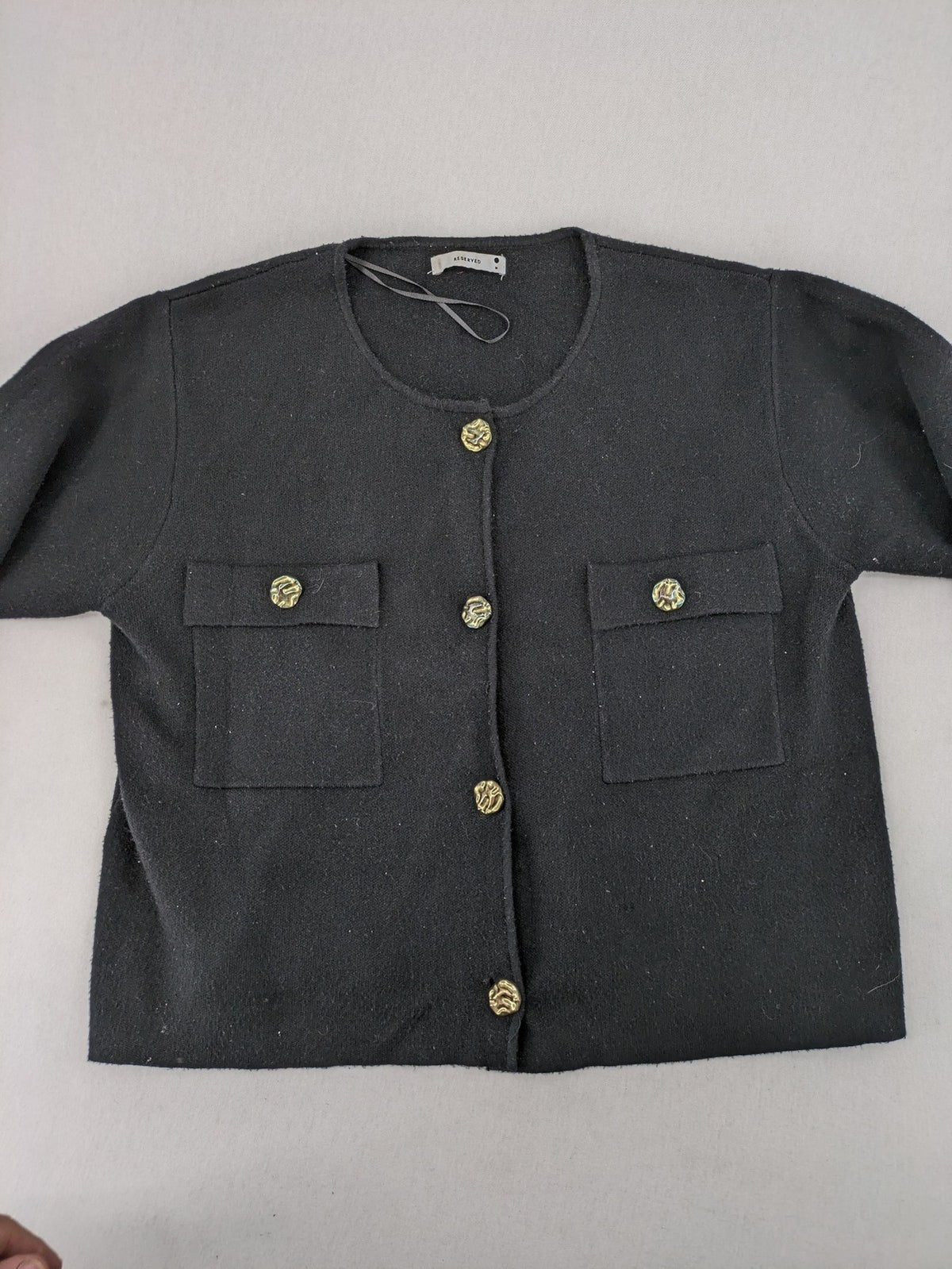 Reserved gold turtle neck jumper with black knit, gold button details and front pockets.