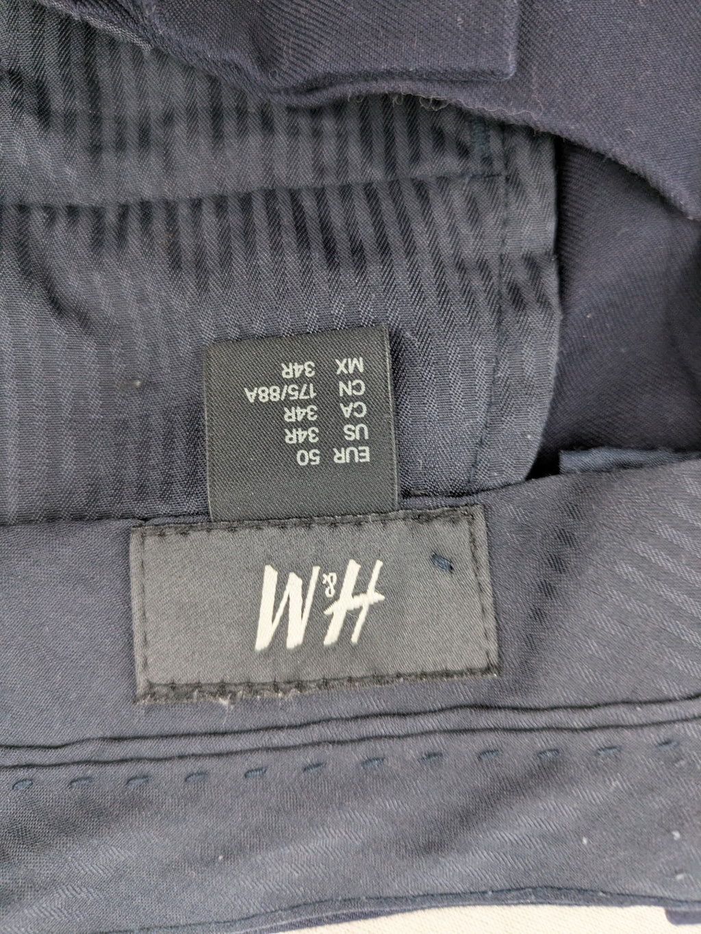 H&M navy slim fit executive suit trousers with flat-front design and side pockets.