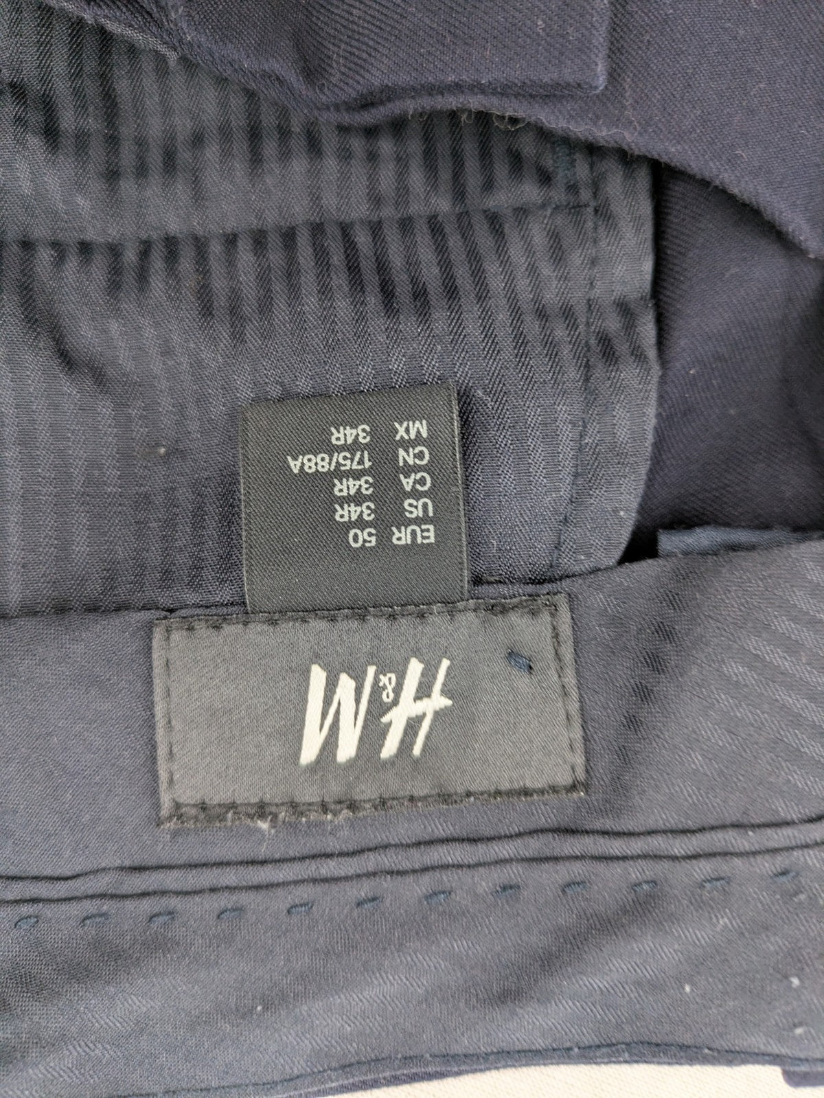 H&M navy slim fit executive suit trousers with flat-front design and side pockets.