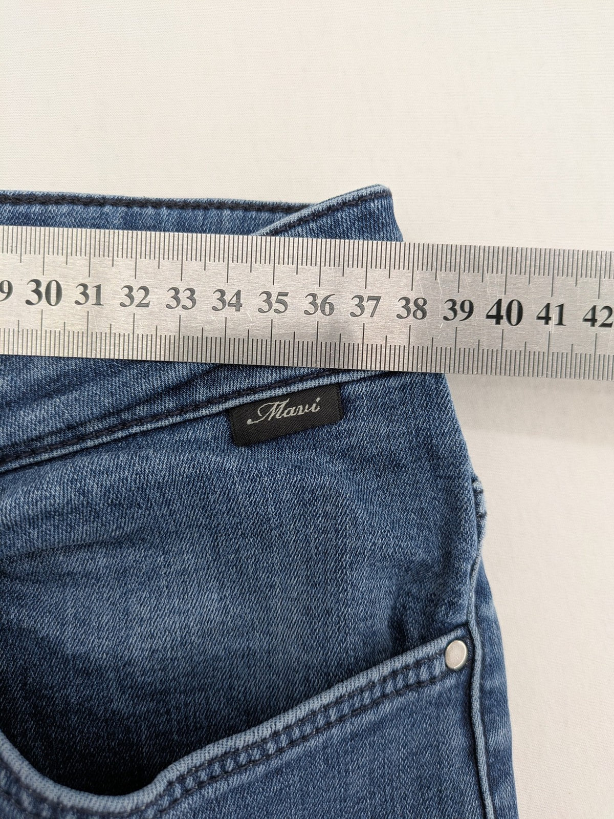 Mavi blue high rise super skinny jeans with medium wash and stretch denim material.