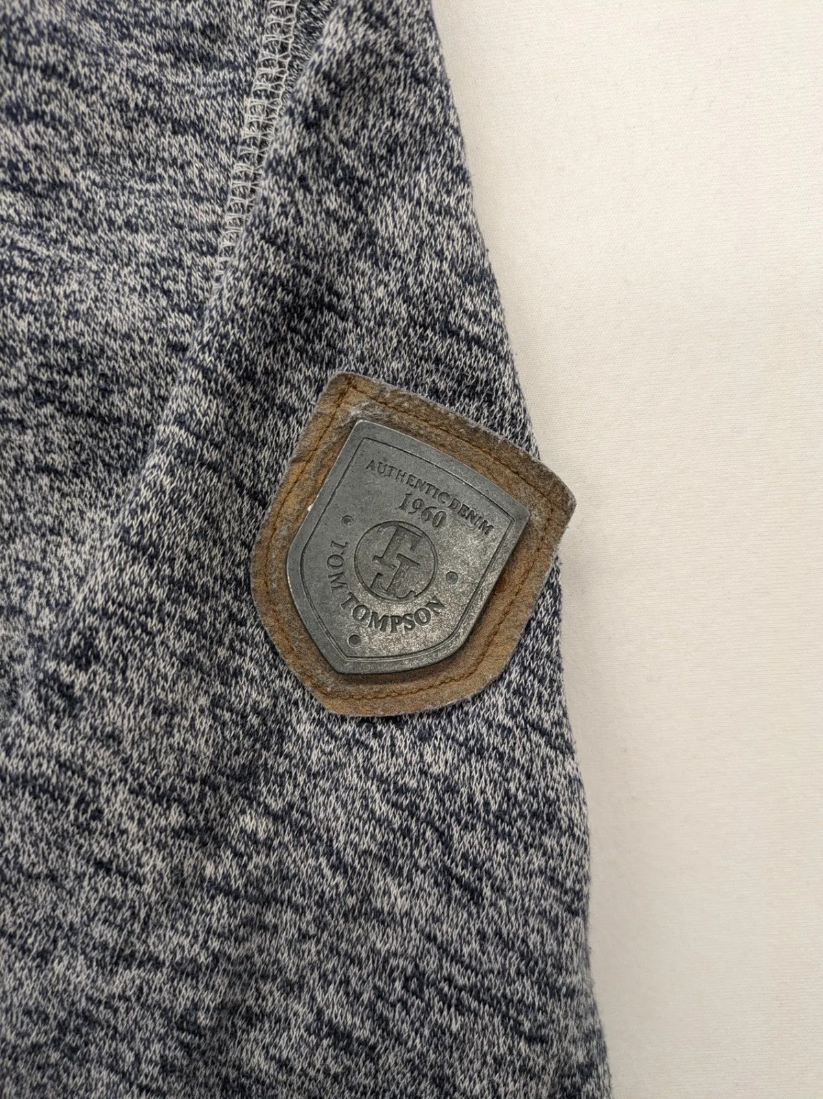 Tom Tompson cream turtle neck jumper with dark blue accents and graphic details on sleeve.