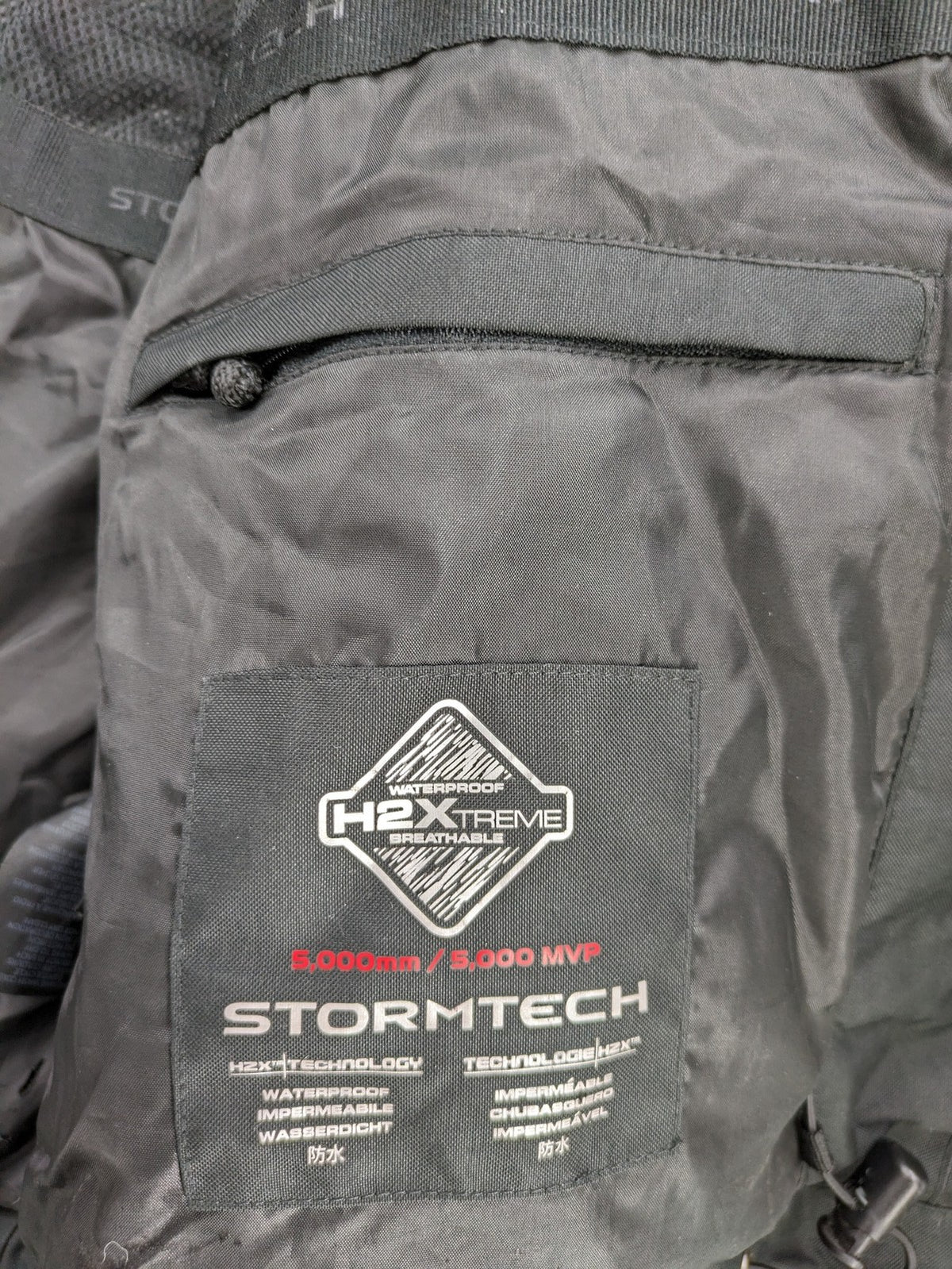 Stormtech black waterproof jacket with ZF logo, H2Xtreme technology, front zipper, and hood.