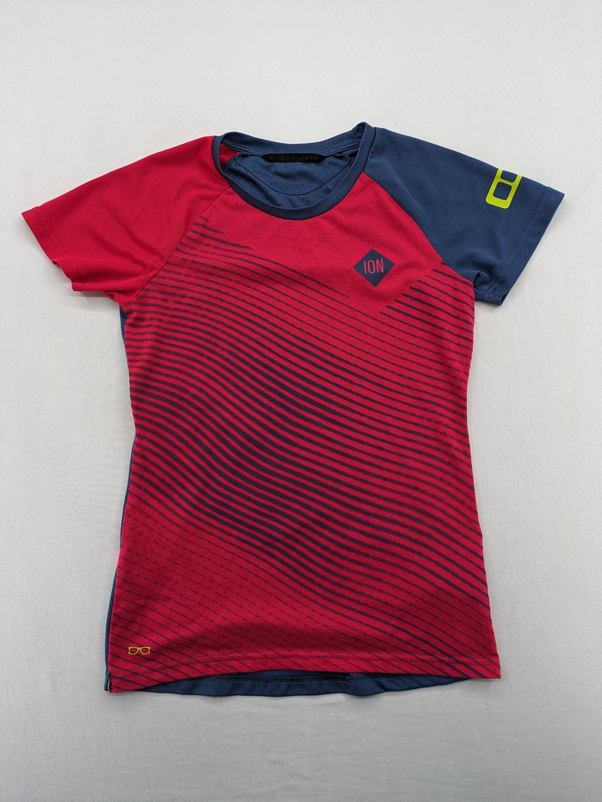 Muster blue and red short-sleeve functional shirt with dynamic wave pattern and raglan sleeves.