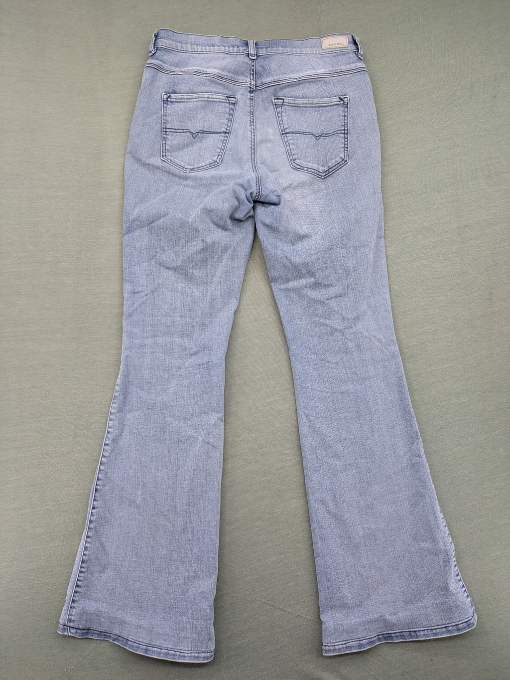 Diesel blue bootcut jeans with white patch pockets and regular waist, stylish stretch material.