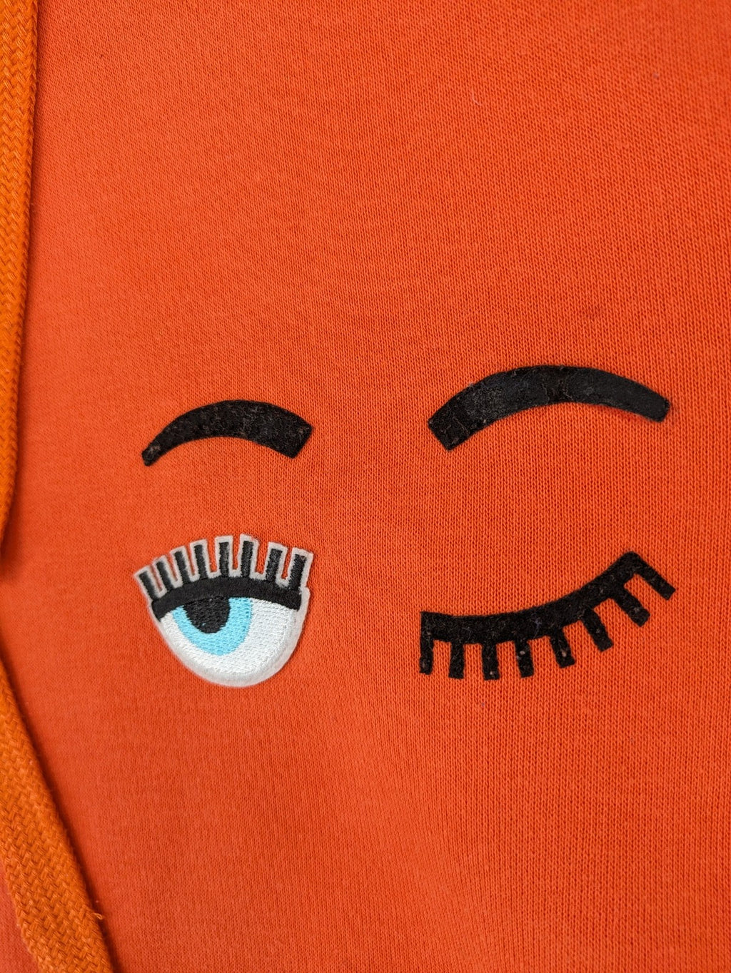 Ginatricot orange hoodie with embroidered winking eye detail, soft material, classic fit.