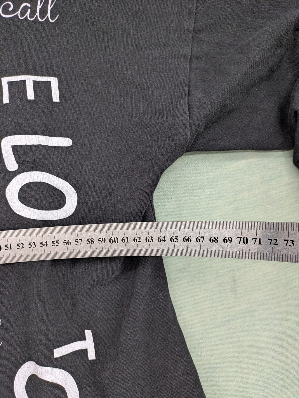 MEGI Collection black hoodie dress with graphic print and asymmetrical high-low hem.