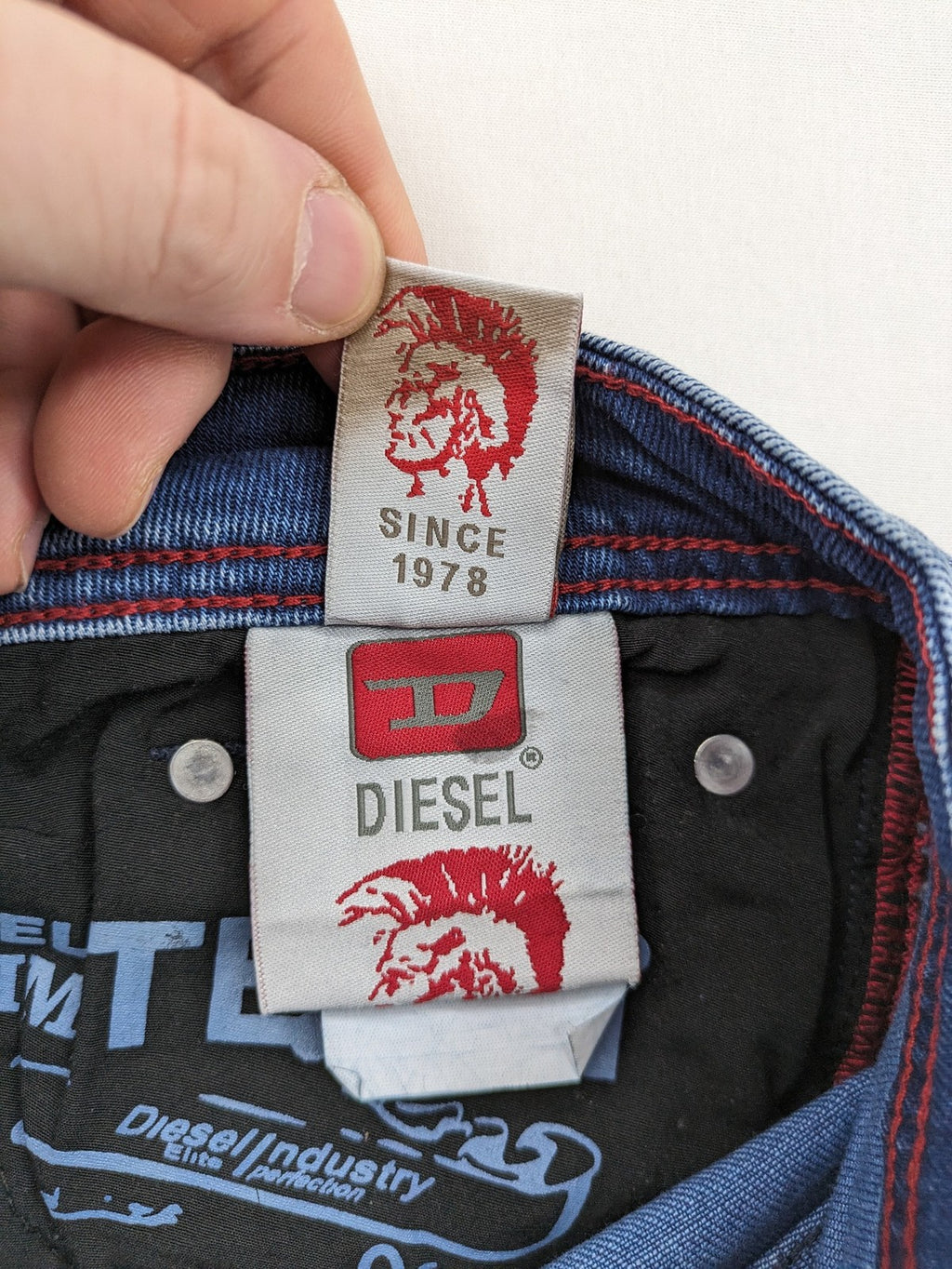 Diesel blue straight jeans with distressed details and ripped accents, made of cotton.