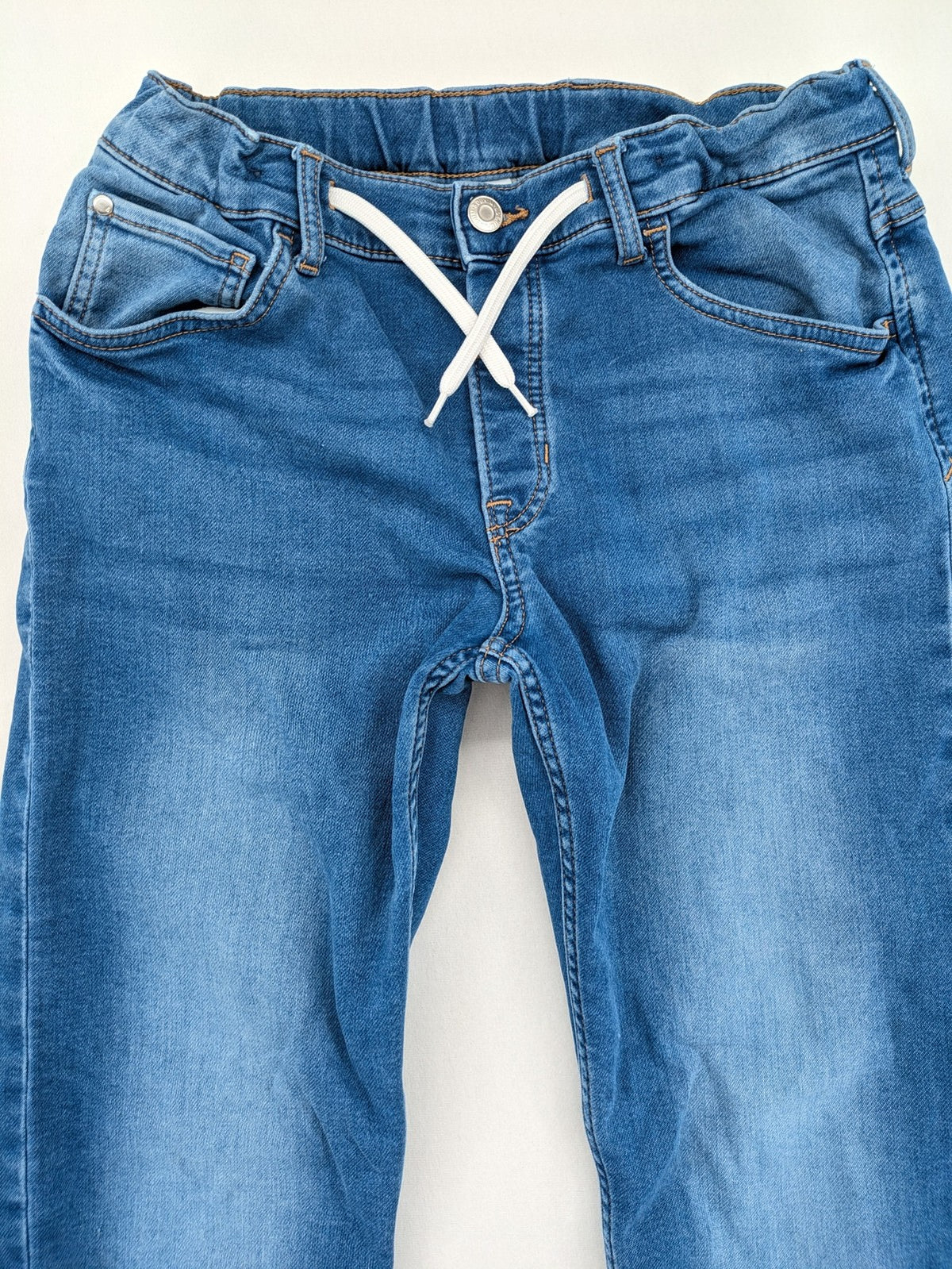 H&M blue straight jeans with elastic waistband and white drawstring, casual jogger style.