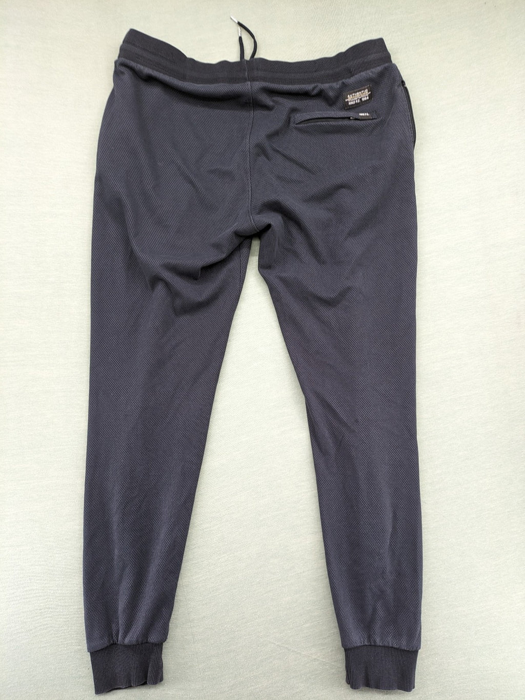 Nike F.C. grey jogger pants with elastic waistband, side pockets, and embroidered Swoosh logo.