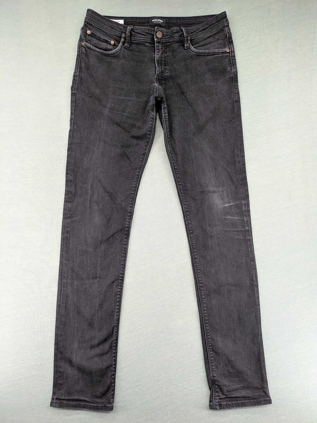 Jack & Jones black slim fit jeans faded wash stretch denim with logo detail.