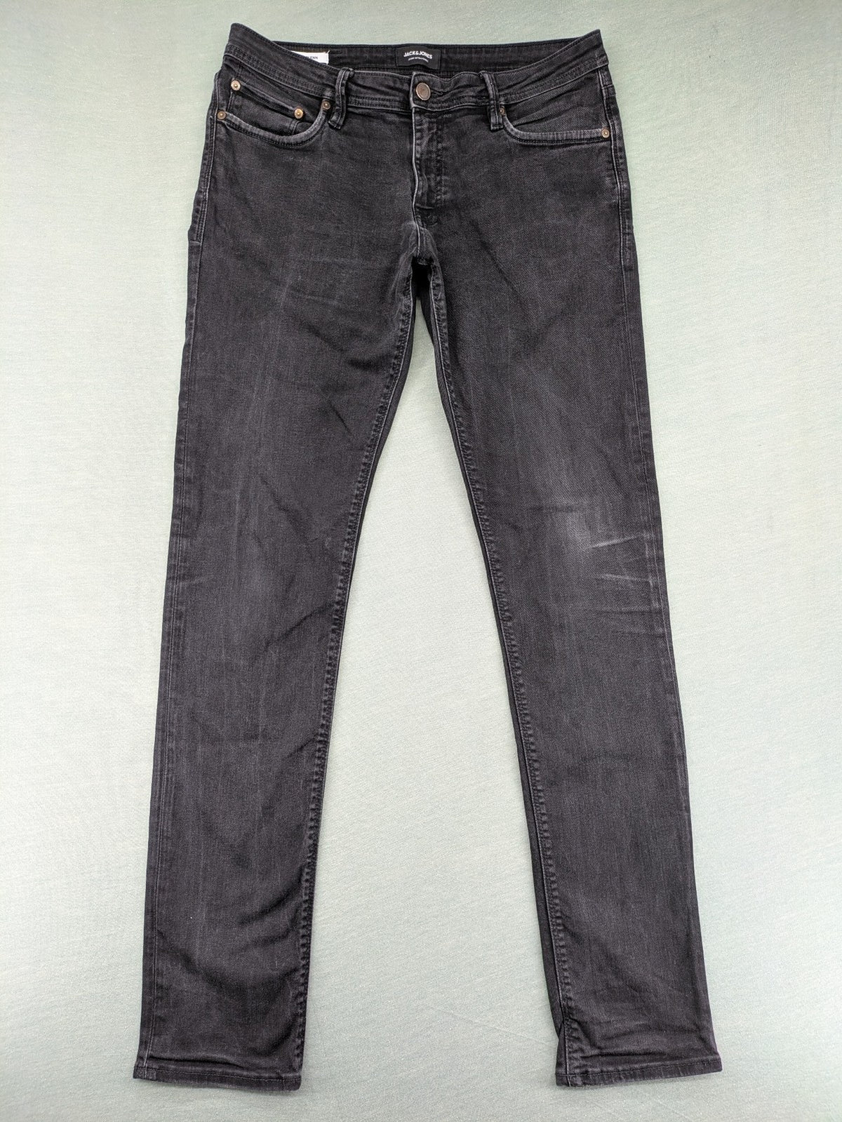 Jack & Jones black slim fit jeans faded wash stretch denim with logo detail.