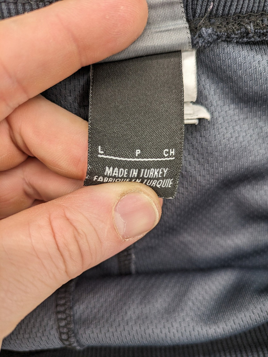 Nike F.C. grey jogger pants with elastic waistband, side pockets, and embroidered Swoosh logo.